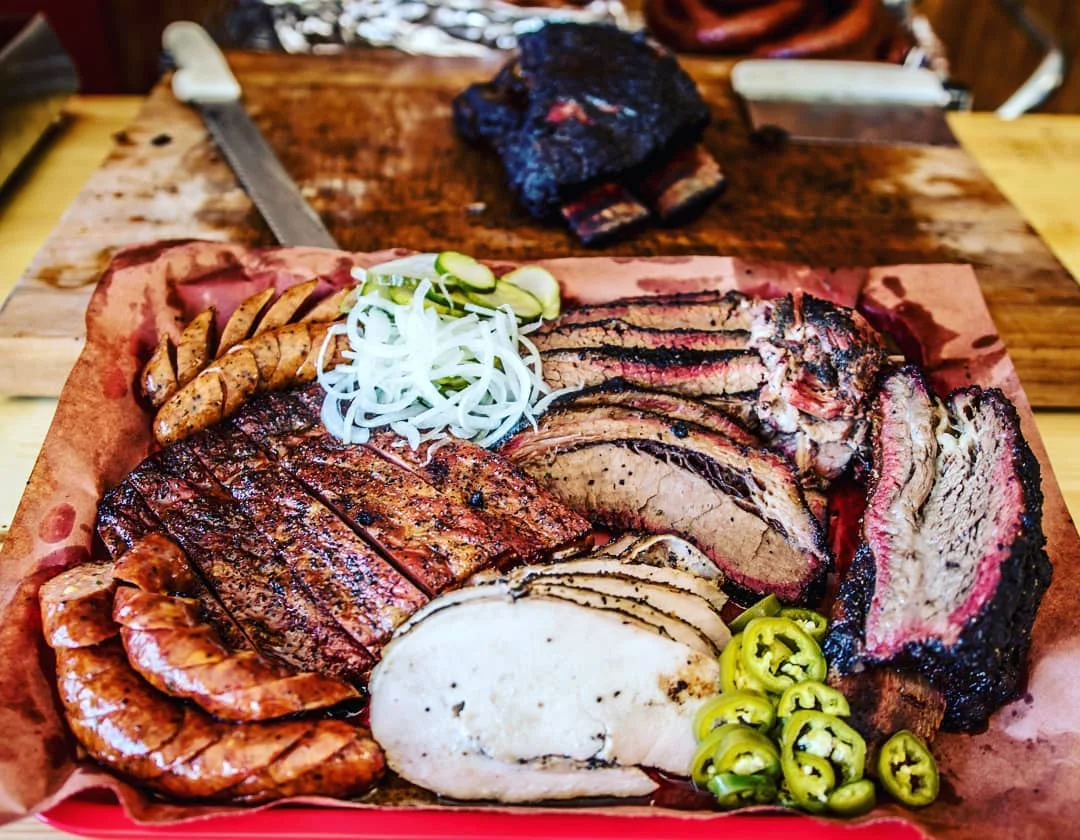FLORES BARBECUE Home: 2222 Highway 22., Whitney, Texas Owner & Pitmaster: Michael Wyont After just one year in business, Flores Barbecue in Whitney was recognized with Texas Monthly Top 50 honors. Flores has quickly become more than a under-the-radar bbq joint. They are now a destination with peppery, oak smoked meats coupled with fresh sides and pickles. The brisket melts in your mouth while the pork ribs provide a perfect bite. Then add in some homemade sausage with some of their famous banana pudding, and you've got a bbq legend in the making. Read More: https://tmbbq.com/flores-barbecue-2016/
