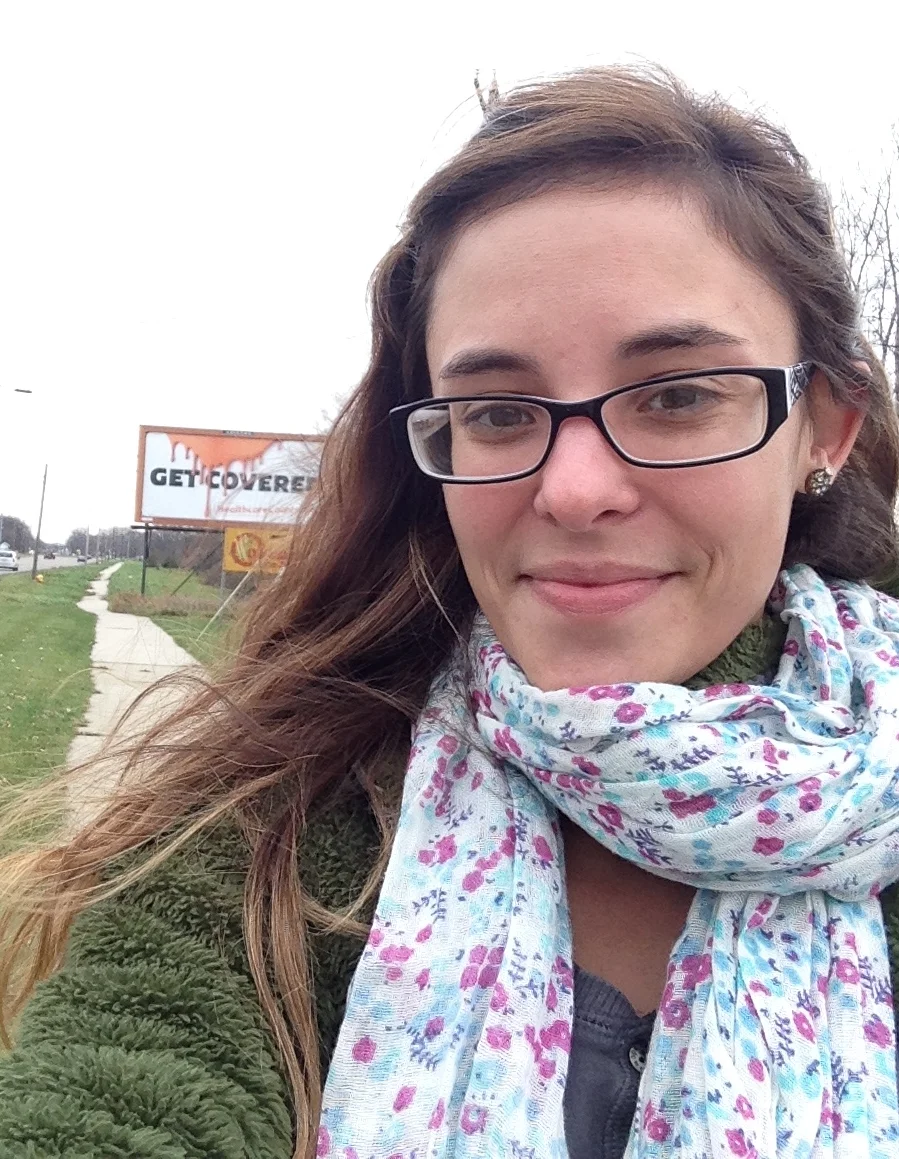 Haley posing with a selfie of herself and the Get Covered billboard in the background.
