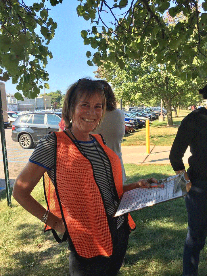 Krista rocks the orange safety vest as she has people check in at a fire safety drill. 