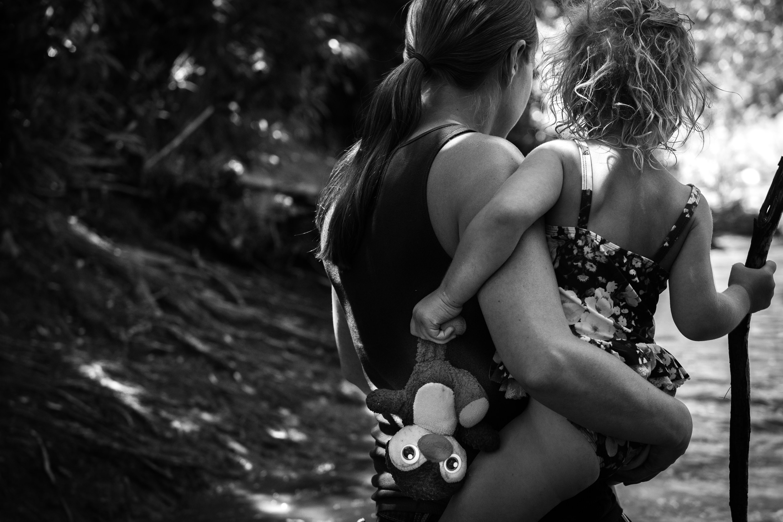 Blog - The Pen & Camera - Molly Rees Photo - Black and White Documentary Childhood Photography - mother holding girl with stuffed animal at Belleview Park in Denver, Colorado by M. Menschel