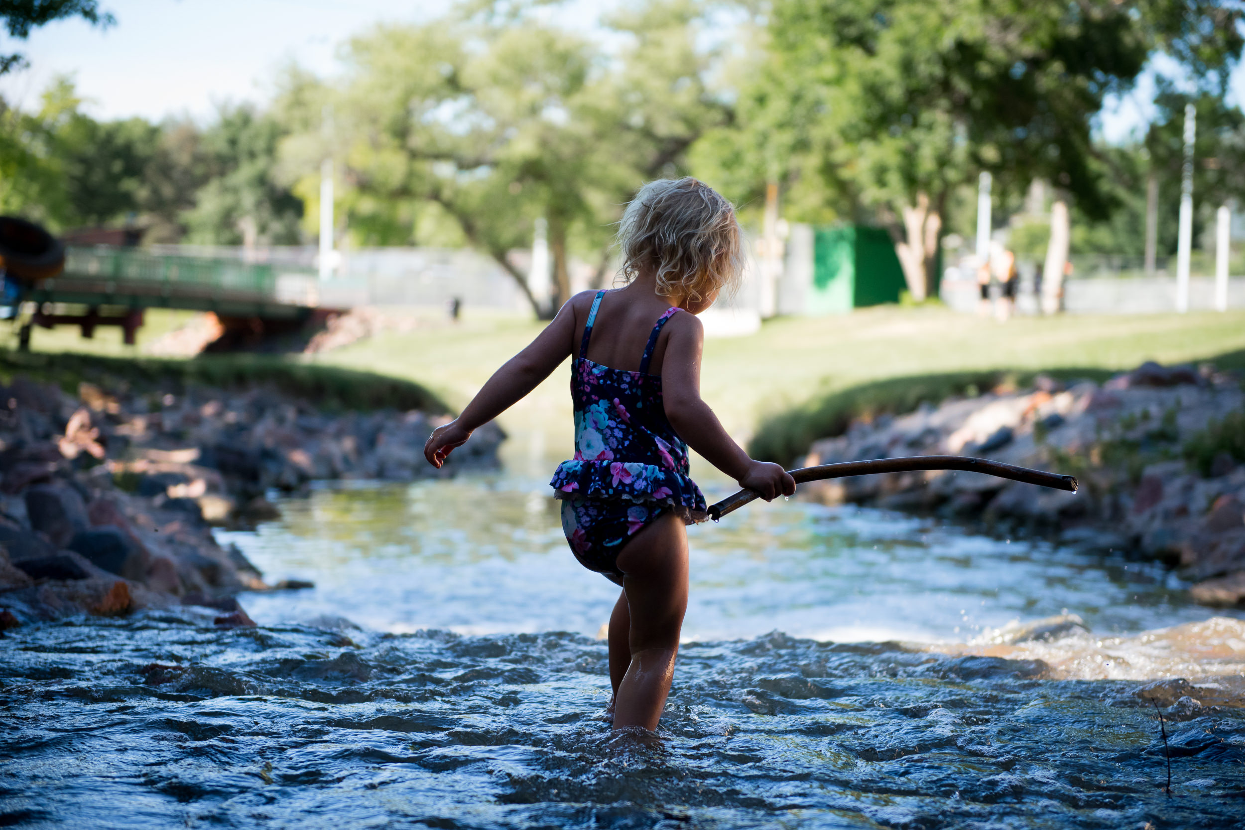 Blog - The Pen & Camera - Molly Rees Photo - Documentary Childhood Photography - girl wading in stream at Belleview Park in Denver, Colorado by M. Menschel