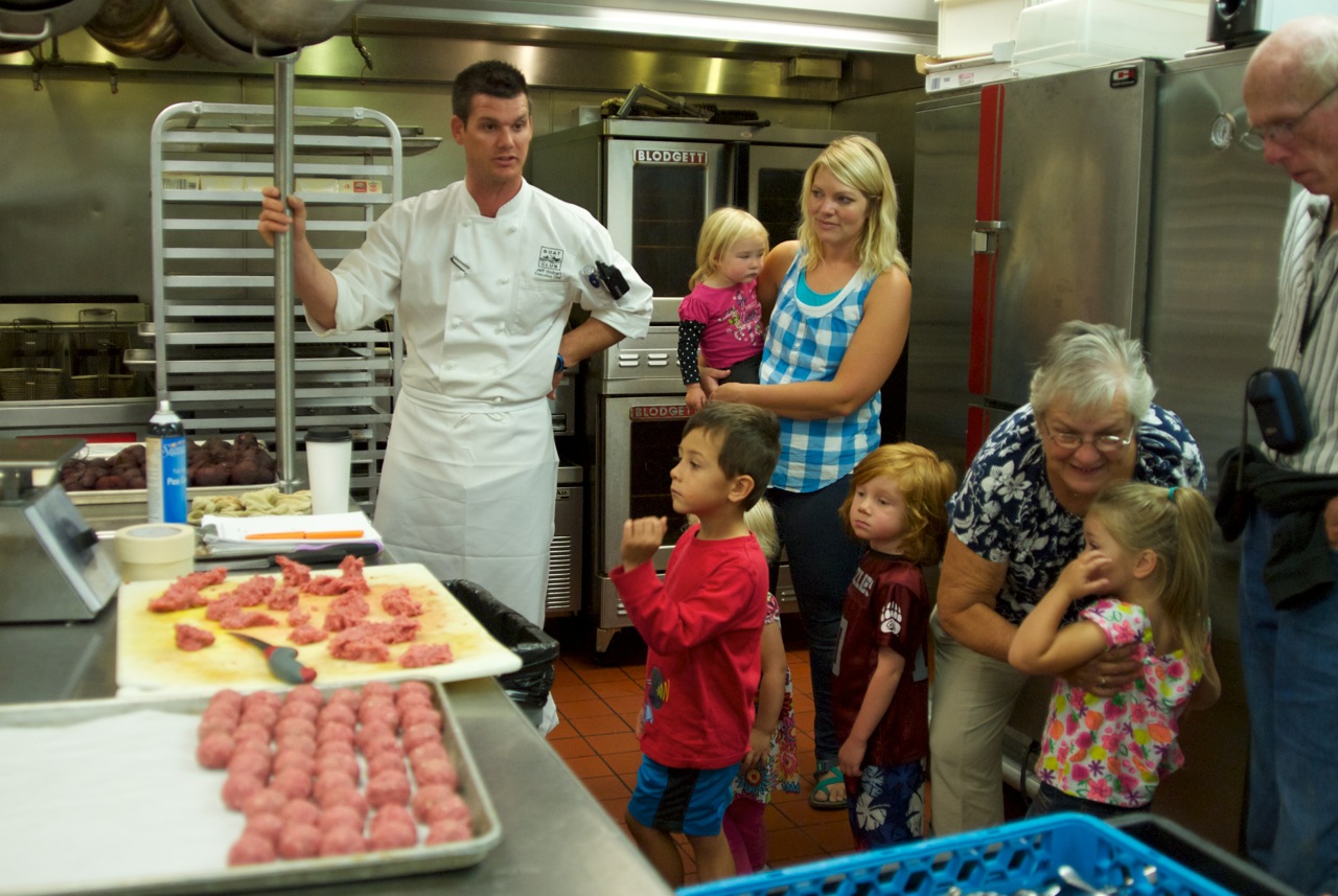 Chef Jeff Hobart giving the students a tour of the kitchen at the Whitefish Lake Lodge. The elk meatballs that were served for the appetizer course can be seen in the foreground.