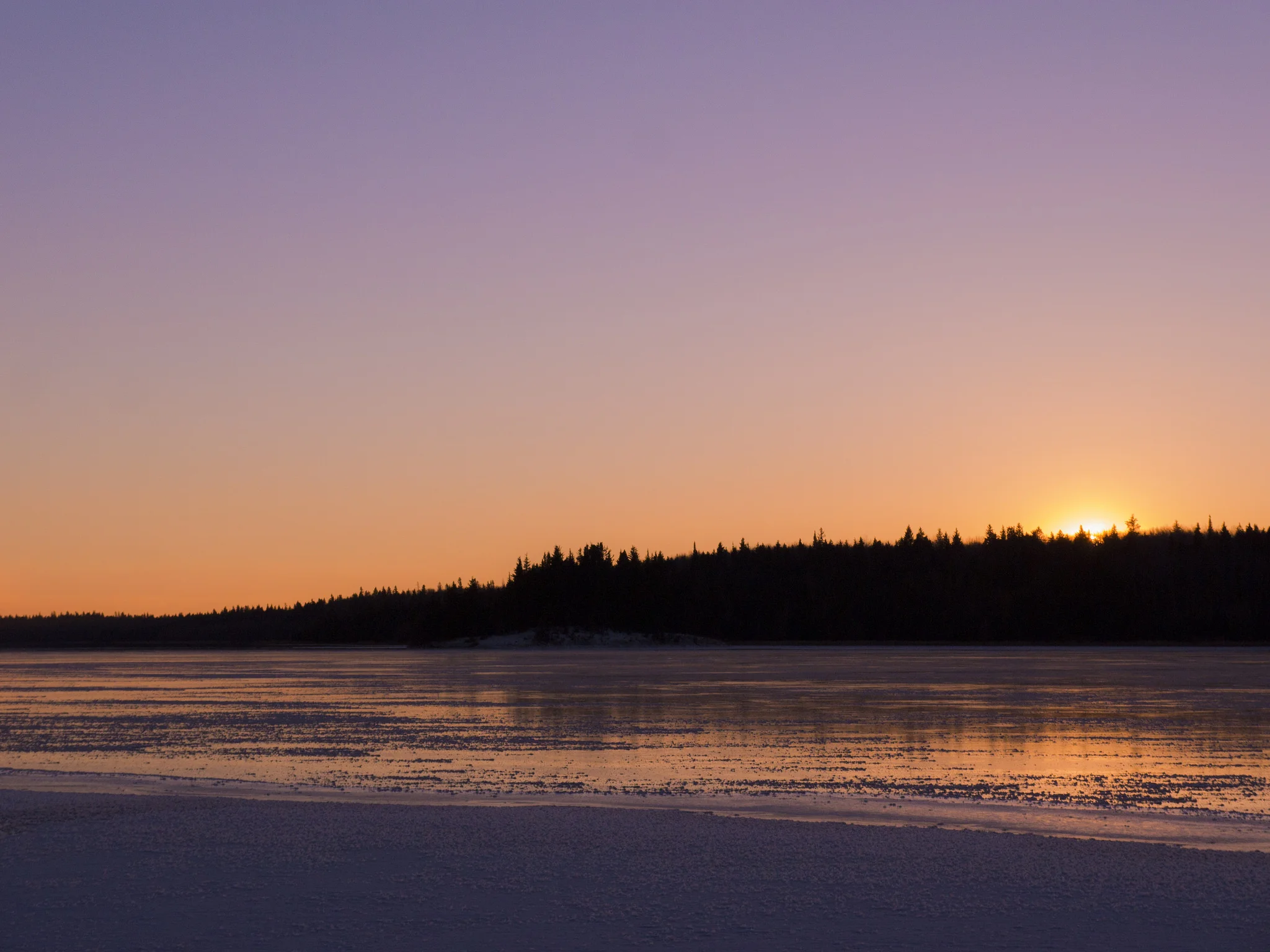 Sun setting over frozen Laurie Lake