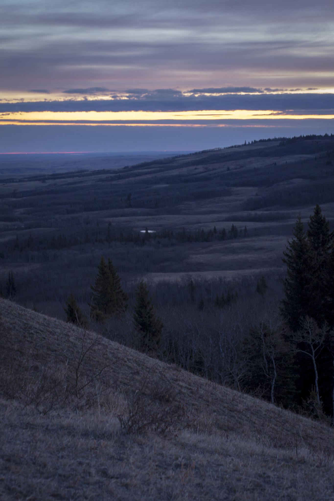 Hiking to Bald Butte - watching the sun rise behind a wall of cloud over the town of Maple Creek and Cypress Hills Interprovincial Park.