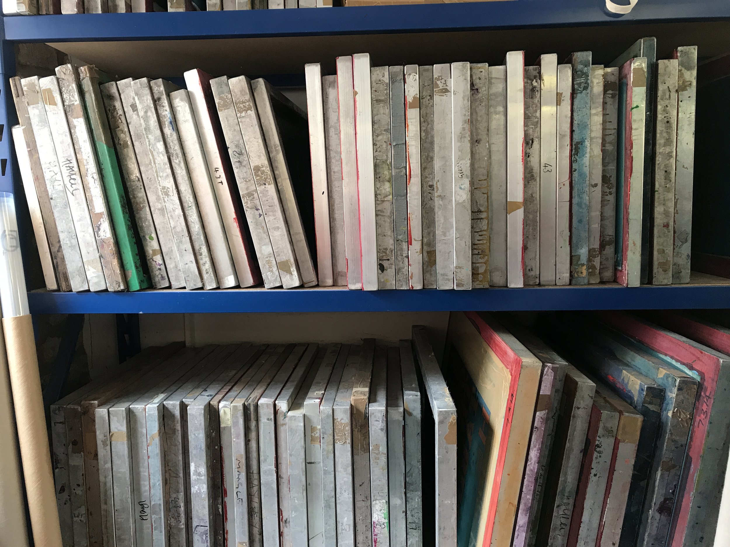 Shelf filled with old, stained sketchbooks or art books, some with visible titles and labels.