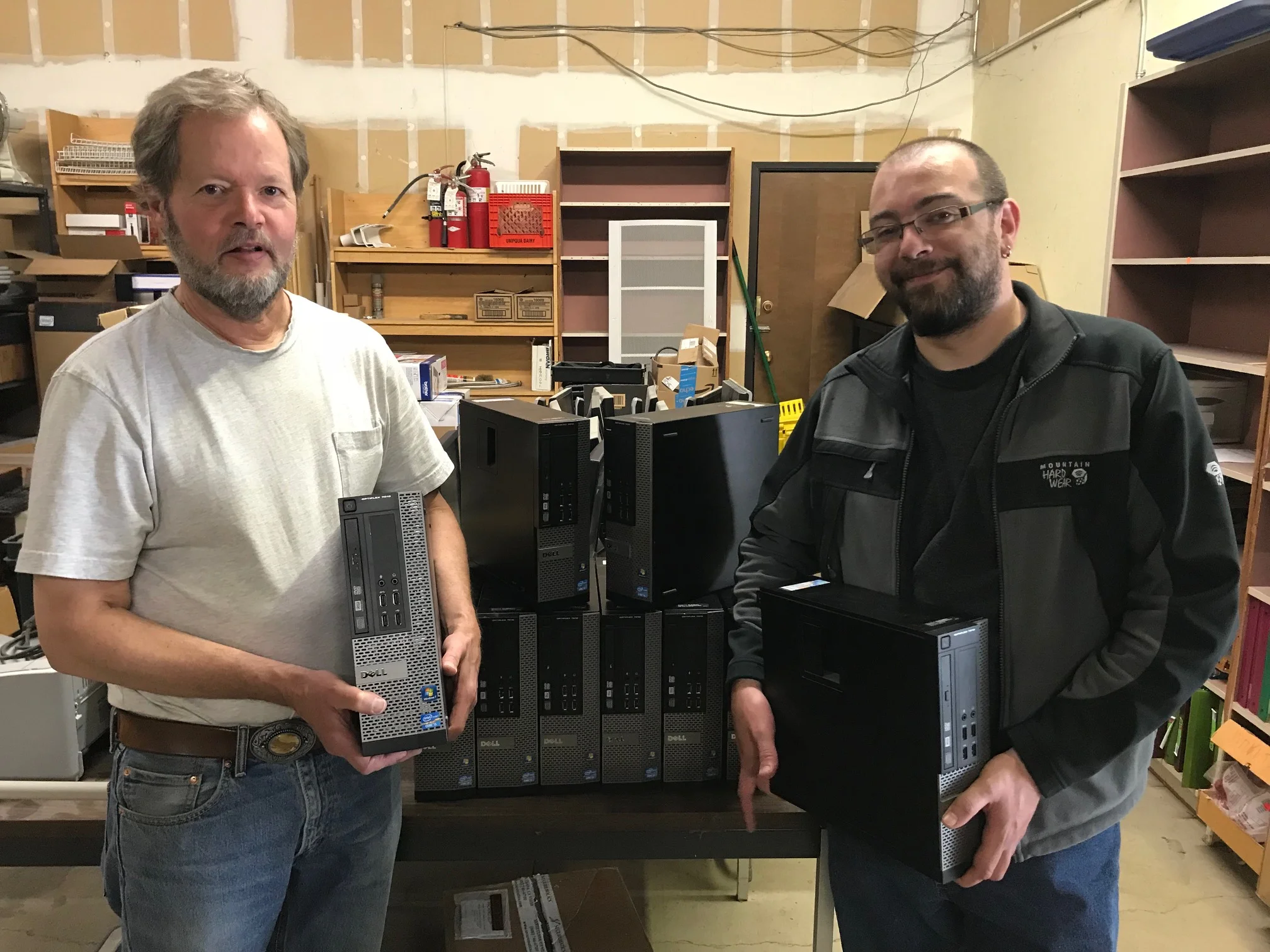 IT Director Jim Carpenter and IT Assistant Loren Tussing show of some of the donated PC towers provided to Looking Glass from SELCO, stored for cleaning and setup at the Looking Glass warehouse.