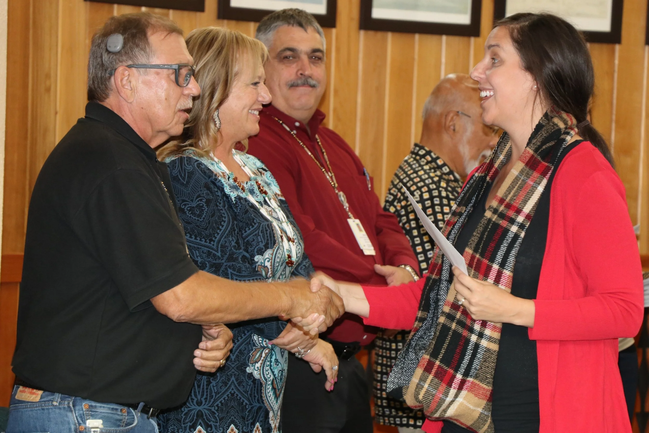 Becca Marx, grant writer for Looking Glass, accepts award and shakes hands with Spirit Mountain Community Fund Trustees (left to right) Jack Giffen, Jr, Denise Harvey, Ron Reibach, and Sho Dozono.