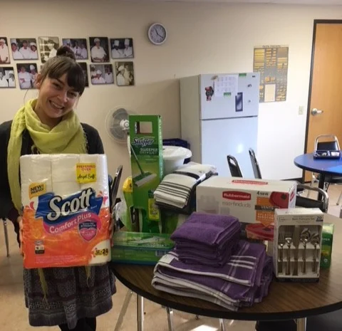 Riverfront Admissions Counselor, Shannon Grosse, displays a variety of items purchased for Looking Glass youth clients using funds donated by SELCO Community Credit Union.