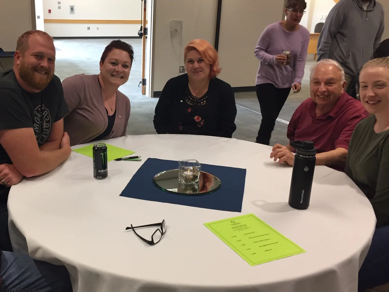 Looking Glass board member Paul Frishkoff (seated, 2nd from the right) sits with Looking Glass staff members at the annual all-staff meeting at LCC. Paul and his wife Pat rarely miss a staff gathering.