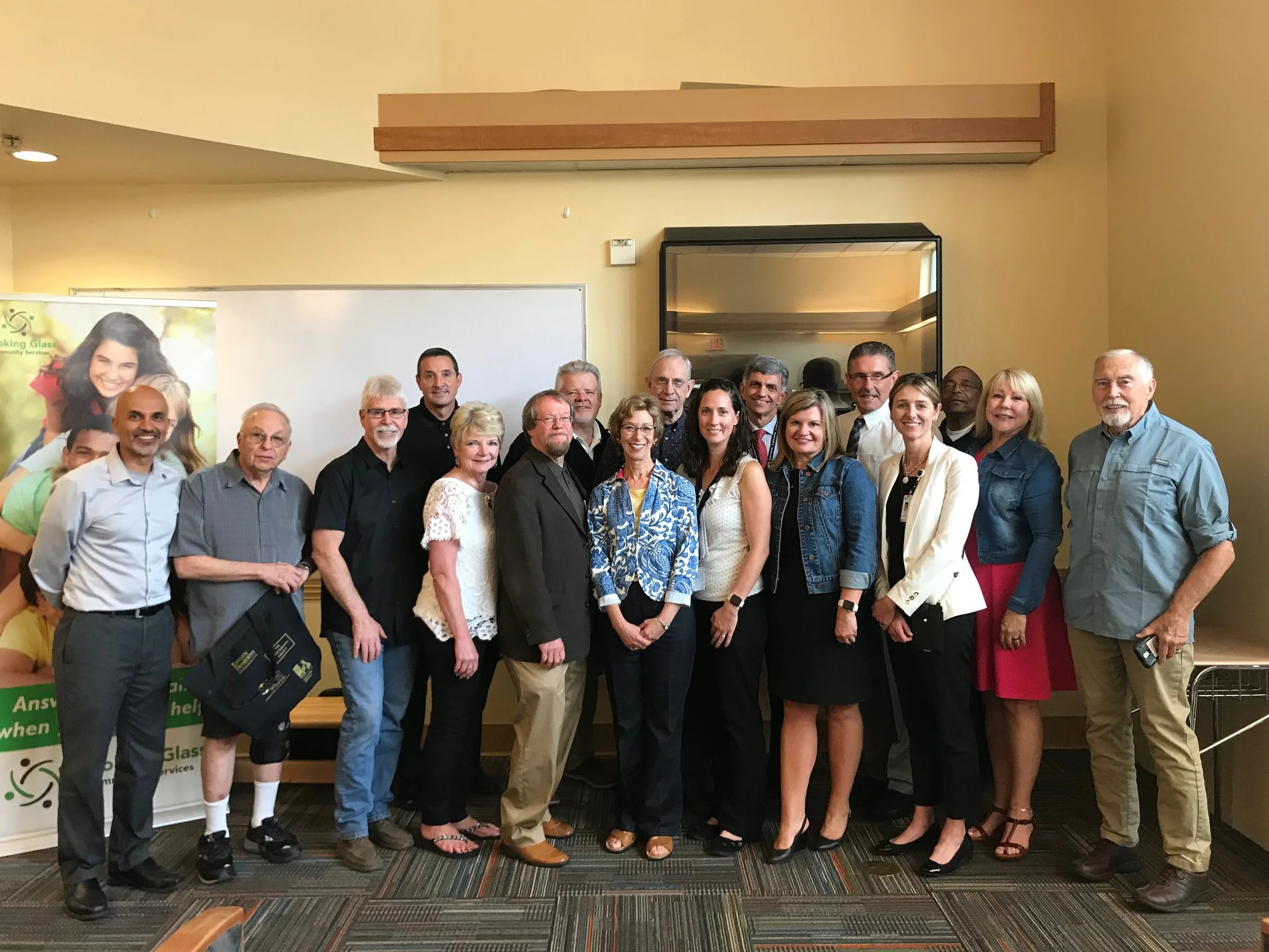 Group photo of Looking Glass staff, board members and supporters at the July 10th gathering including state representative Nancy Nathanson and Fariborz Pakseresht, DHS Director and other DHS staff.