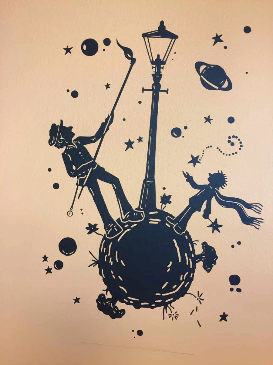 Little Prince montage. 18"h x 12"w (Easy to apply)Black graphic on orange wall.