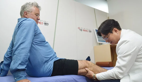 송준섭(오른쪽) 서울제이에스병원 병원장이 거스 히딩크 2002한일월드컵 한국 축구대표팀 감독의 무릎을 살펴보고 있다. 히딩크 감독은 지난해 1월 이 병원에서 퇴행성관절염 수술을 받았다./서울제이에스병원 제공