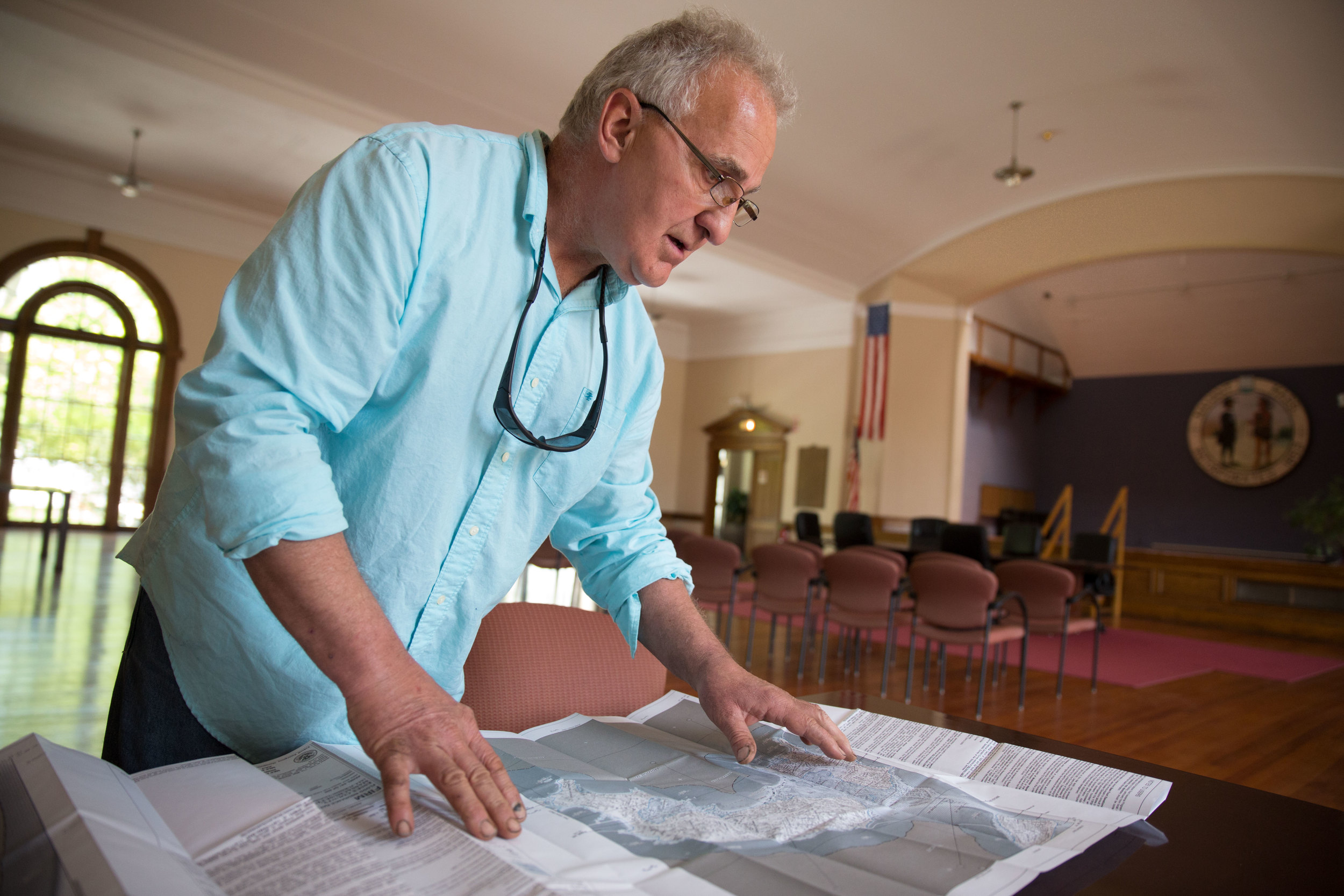 Enzo Barile, a local elected official who has taken on heading up the town's preparedness measures, pours over federal flood-risk maps for Nahant.