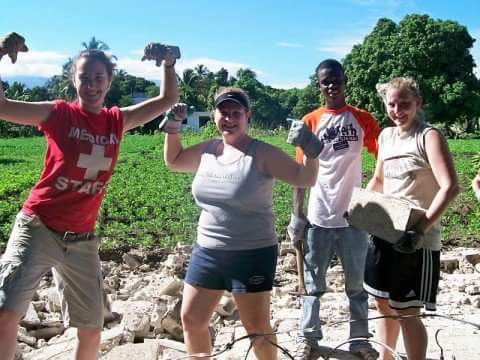 Courtney Christman, Emily Schlegel, a Haitian teen, and Sara Trupp build a fence. | Credit: Megan Trupp