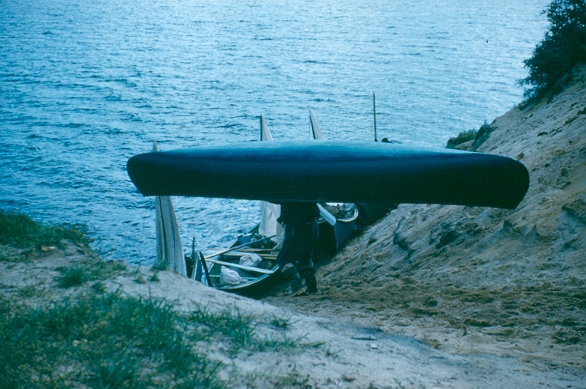 A Cree man carries his canoe to the river, 1960s. Credit: Reverend Don Ruggles, courtesy Chisasibi Heritage & Cultural Centre