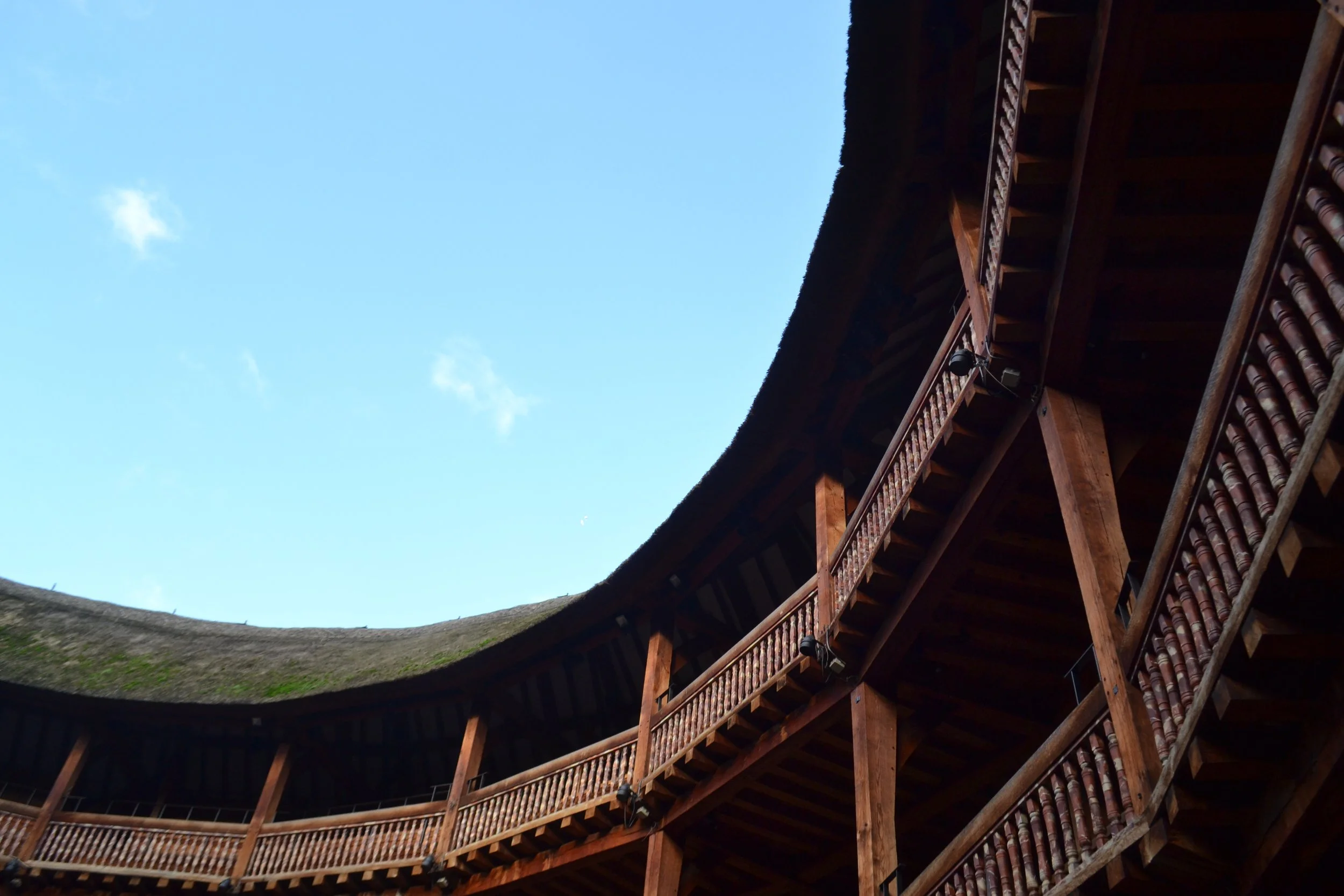 Several balconies of an outdoor theater curve out of the shot. A blue sky rests above.