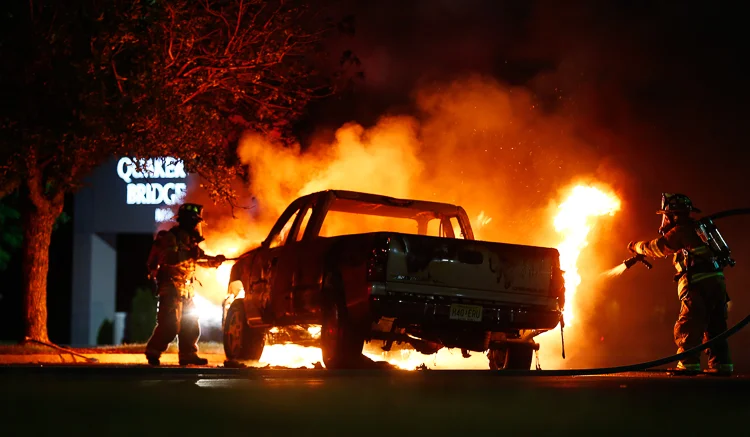 Firefighters with the Slackwood Volunteer Fire Co. in Lawrence Township, work quickly to put out a fire which fully engulfed a pickup truck in the parking lot of Quaker Bridge Mall. Lawrence Township, NJ 6/12/15 (Photo Credit: Saed Hindash)