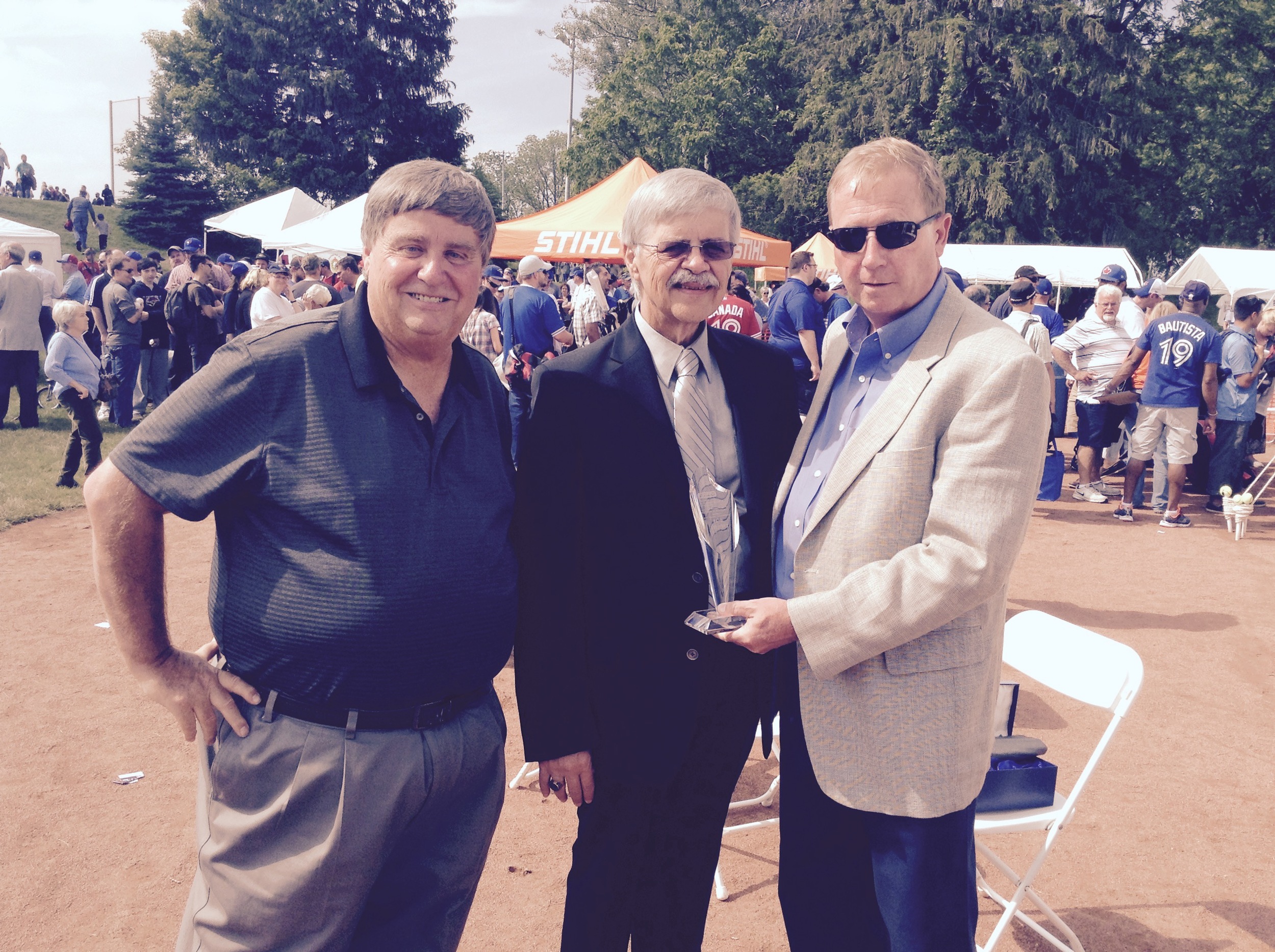 John Jepson, left, president of the Premier Baseball League of Ontario and his league vice-president Don Campbell, right, present Bob Elliott with a lifetime achievement award in St. Marys.