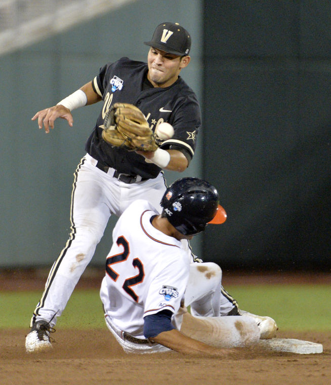 Virginia Cavs SS Daniel Pinero (22) slides into second base against the Vanderbilt Commodores. The Cavs edged Vandy 4-2 to win the College World Series in Omaha.