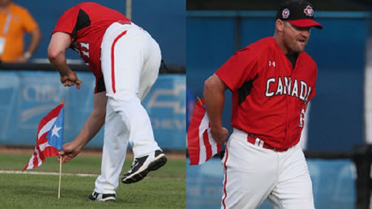 Canadian coach Stubby Clapp disposes of a Puerto Rico flag Carlos Baerga placed on the mound before the semi-final game. Photo: Vernoica Henri.