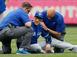 Blye Jays trainers Mike Frostad and George Poulis tend to injured SS Troy Tulowitzki Saturday afternoon at Yankee Stadium.