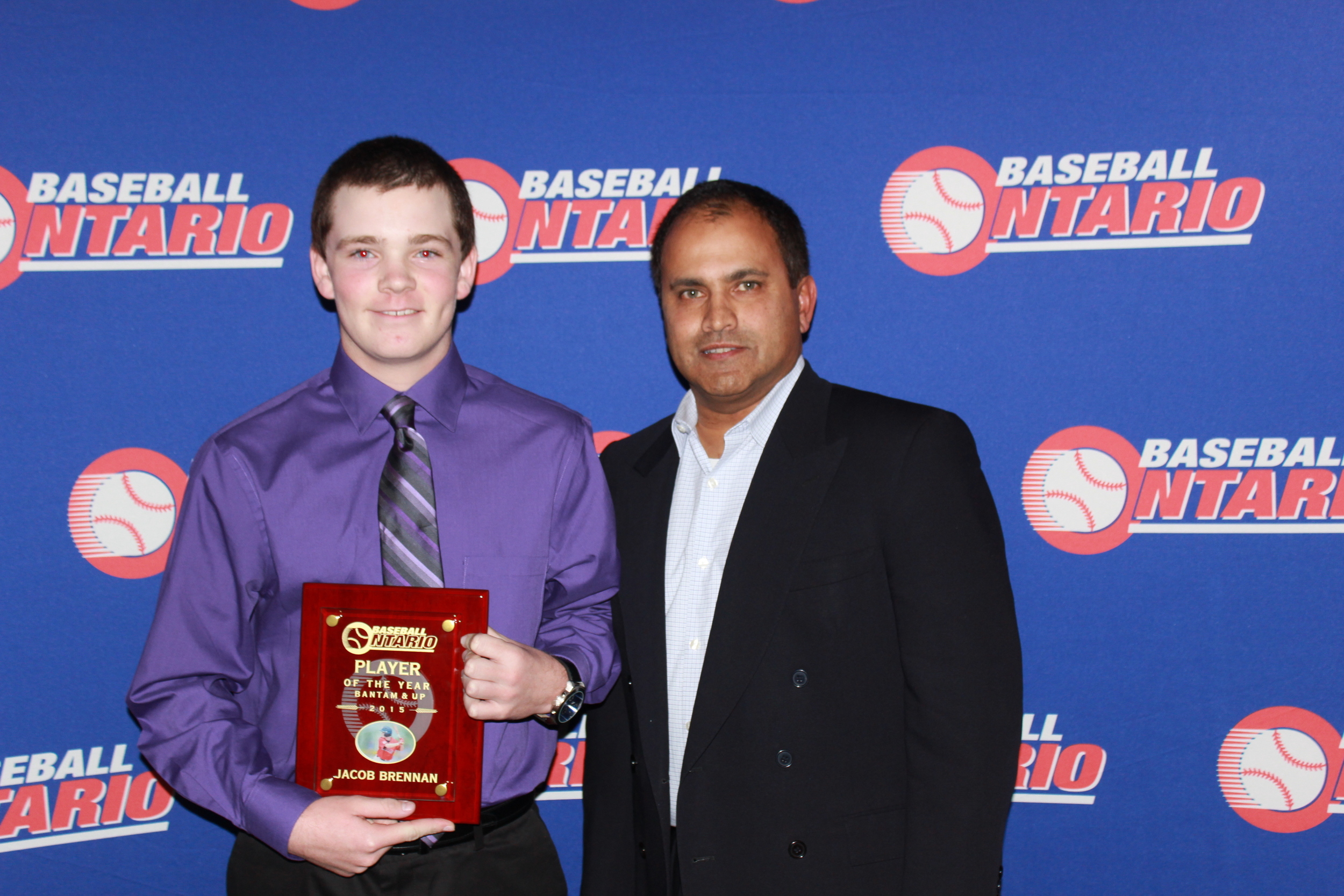 Jacob Brennan of the Barrie Red Sox is presented is OBA player of the year award by director Dirk Drieberg.