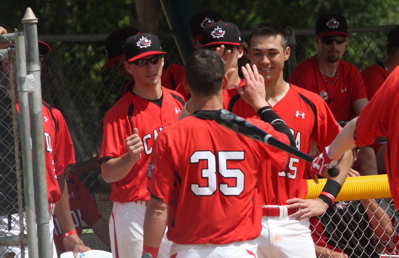  No. 35 Steven Moretto (Burnaby, BC) returns to the dugout after scoring in the Canadian Junior National Team's win over the Dominican Summer League Cubs. Photo: Adam Morissette.