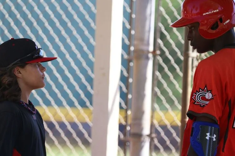 All-star bat boy Ty Hamilton (Ottawa, Ont.) asks Clarke if he can tell him how to find the nearest barber shop. Hamilton found a barber shop in Ottawa on his own. Photo: Amanda Fewer. 