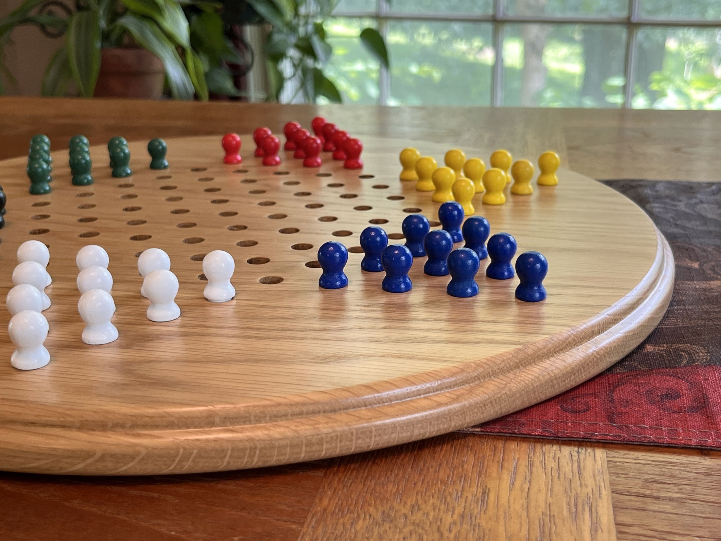 Side view of an oak Chinese checkers board showing the rounded edge.