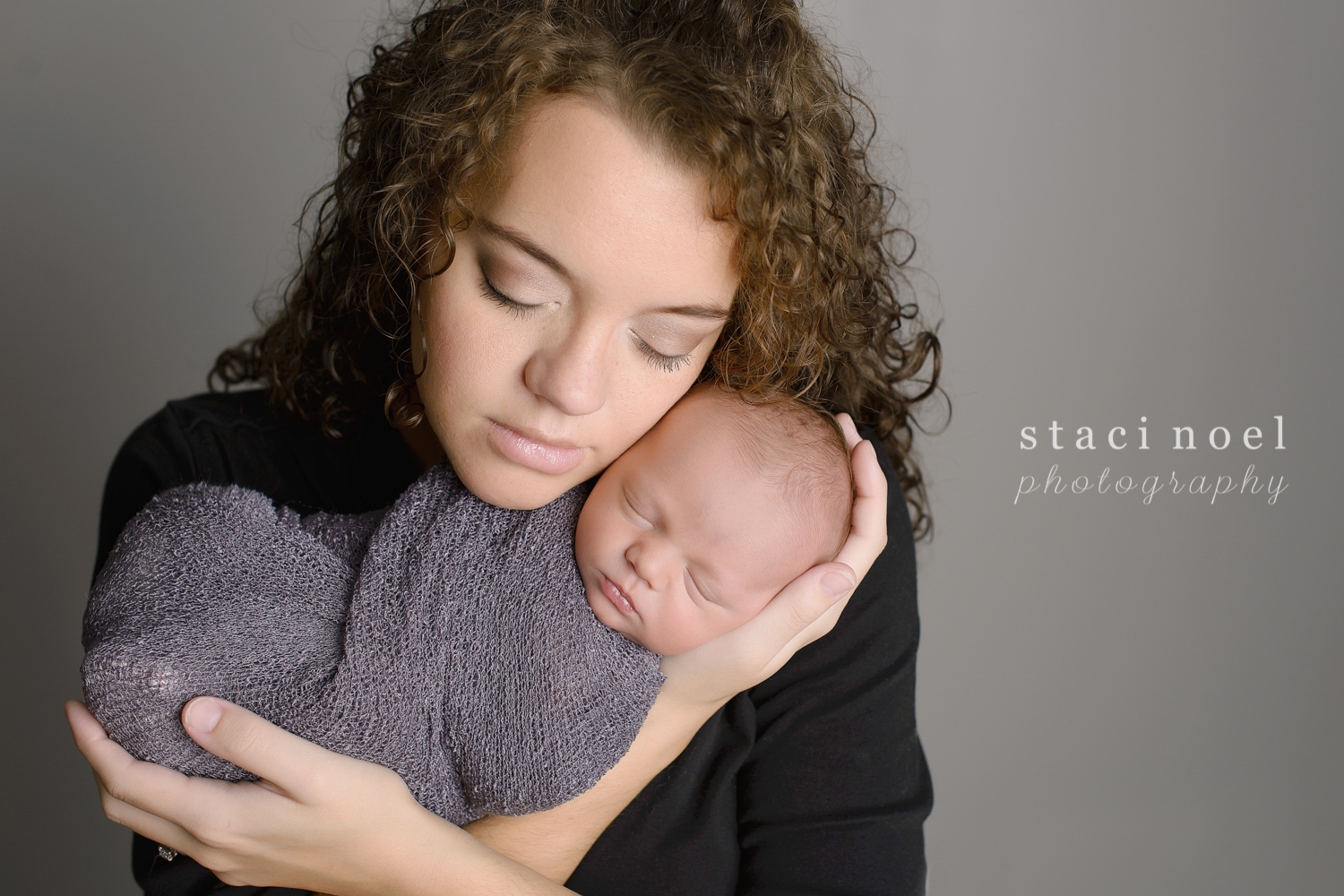 Newborn baby boy in Concord, NC photographed by Staci Noel photography with his mother on grey backdrop.