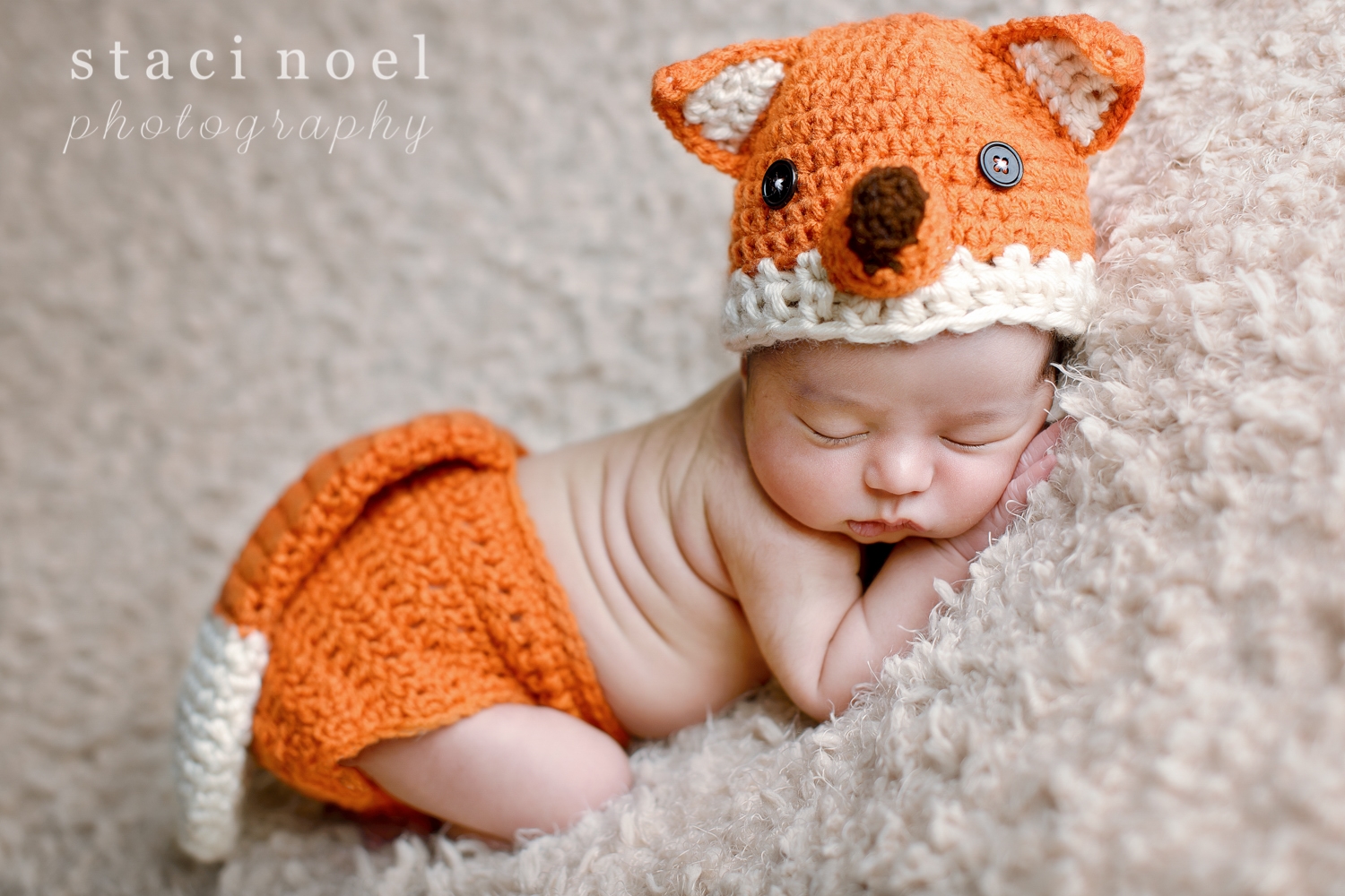 Charlotte NC newborn baby girl photographed by Staci Noel photography in crocheted fox outfit on tan backdrop