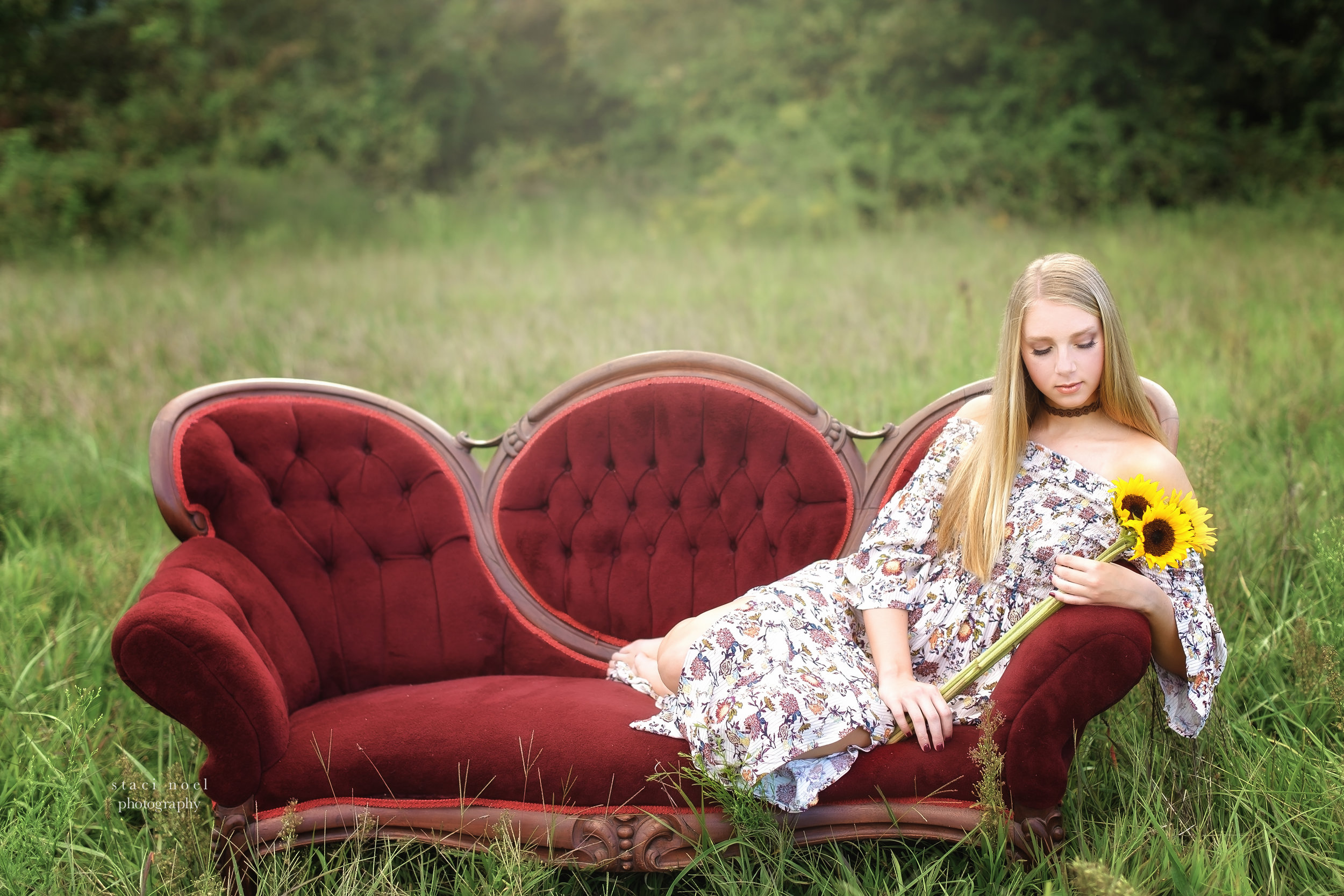  staci noel photography portraits of high school senior girl in dress in a summer field in Harrisburg NC on a red sofa    