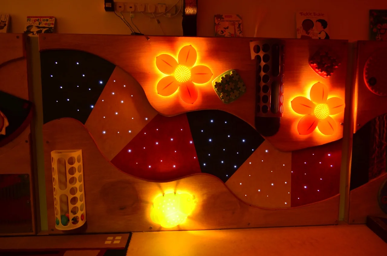The Sensory Wall The sensory wall stimulates the senses, where children can touch and feel the different textures; watch the twinkling stars, lighted flowers and bugs; look at their reflections in the mirrors; explore how things work by posting, sticking and tapping.