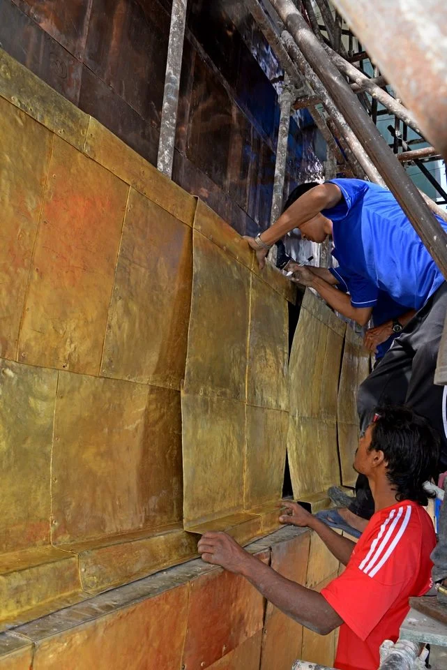 Gold plated panels being installed on the iron framework