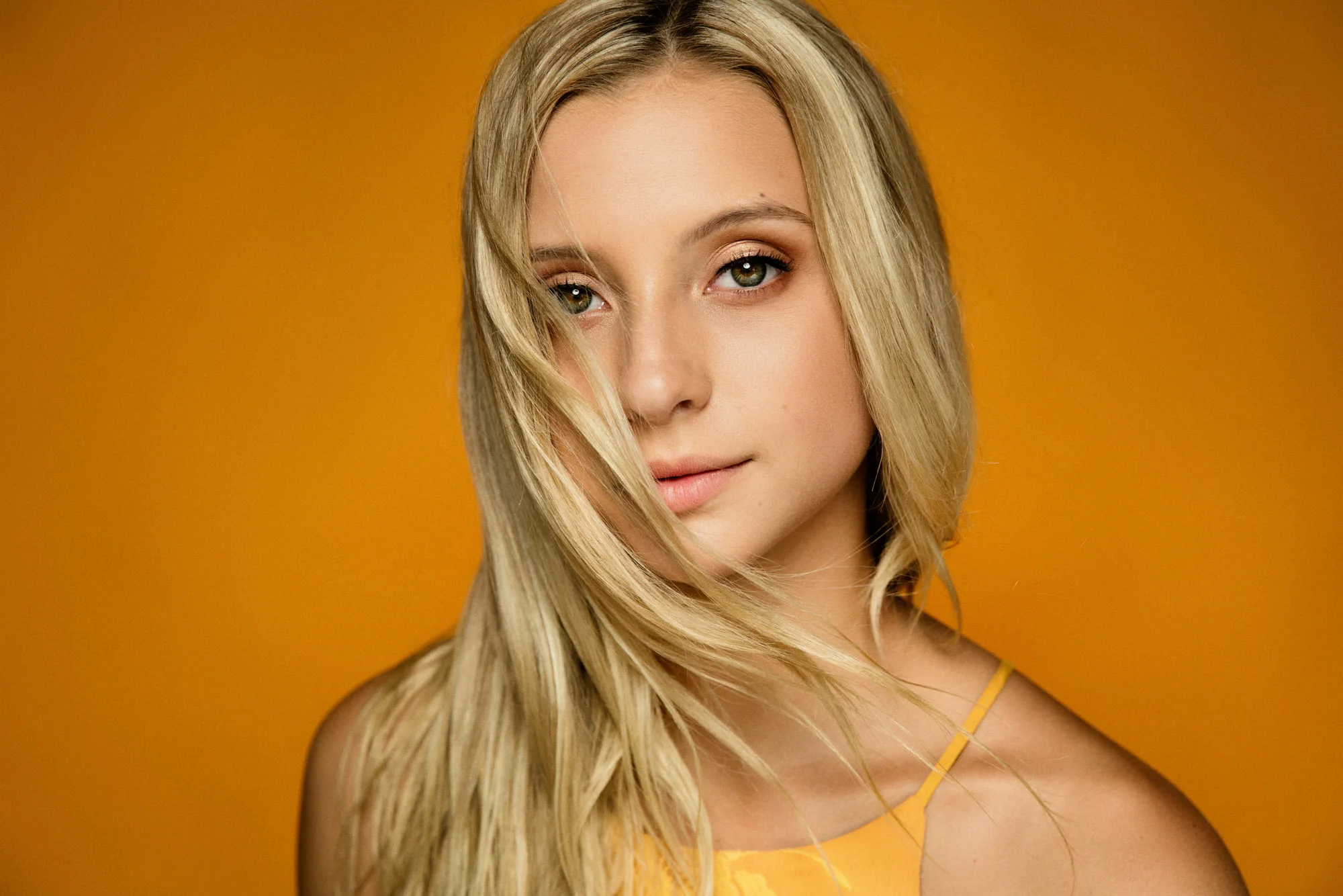 Senior girl on orange background in studio