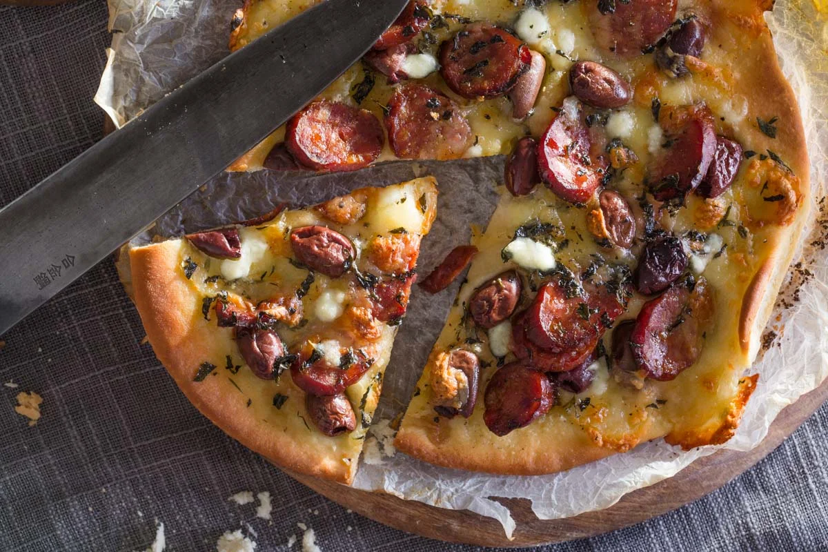 Pizza flat bread with chorizo, olives, garden fresh herbs and bocconcini