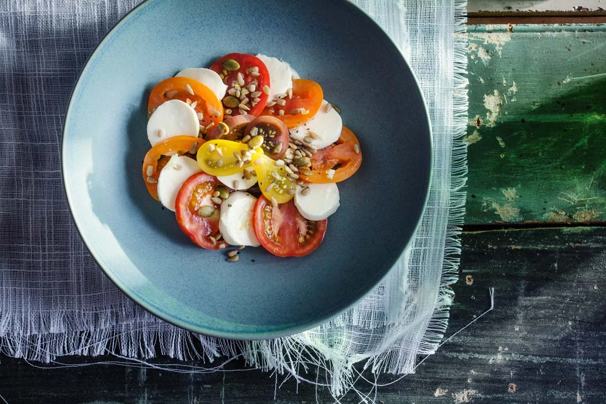 Caprese style salad with basil oil, balsamic reduction bocconcini, heirloom tomato's and toasted seeds