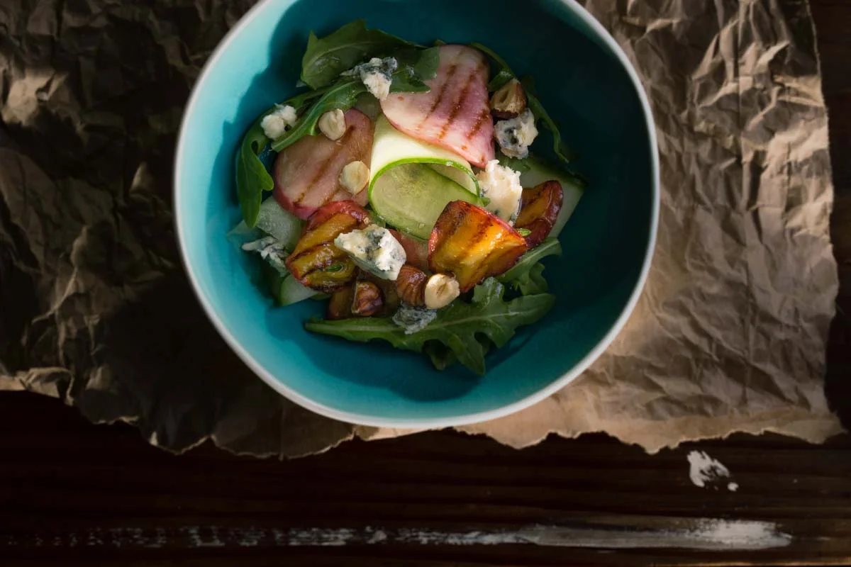 Grilled stone fruit salad with rocket, Dolce Gorgonzola, toasted hazel nut, cucumber ribbons and maple syrup dressing
