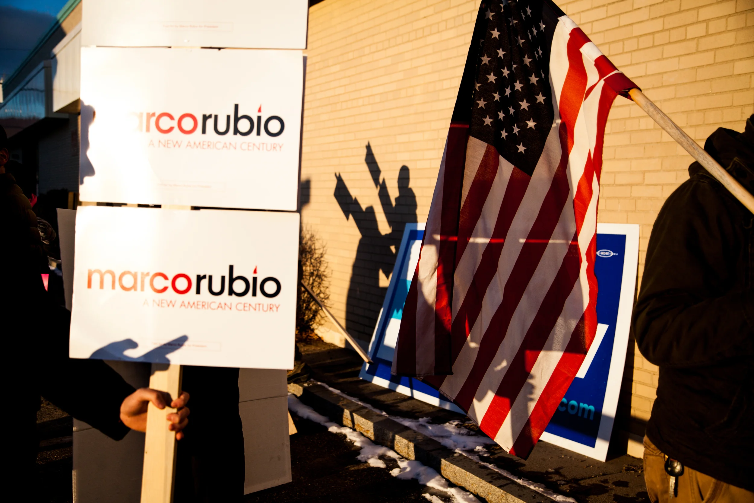 Supporters of Donald Trump, Hillary Clinton and Marco Rubio talk to voters by the entrance of a polling station at the Manchester Health Department in Manchester, New Hampshire, on February 9.