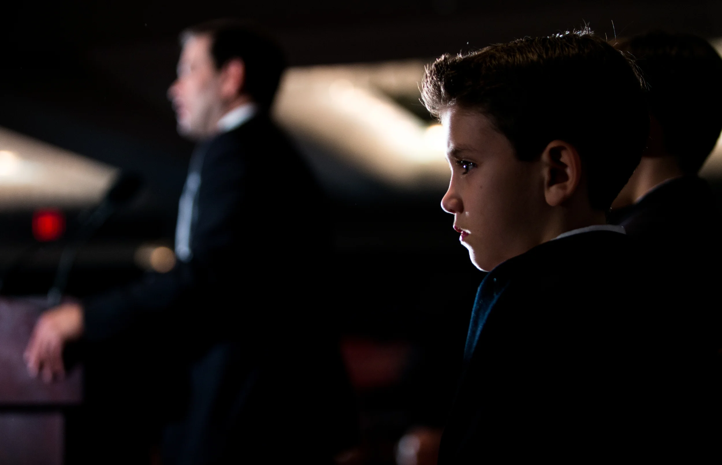 Republican presidential candidate Sen. Marco Rubio (R-FL) (left) speaks as his son Anthony Rubio looks on during a primary-night party at the Radisson hotel February 9 in Manchester, New Hampshire.