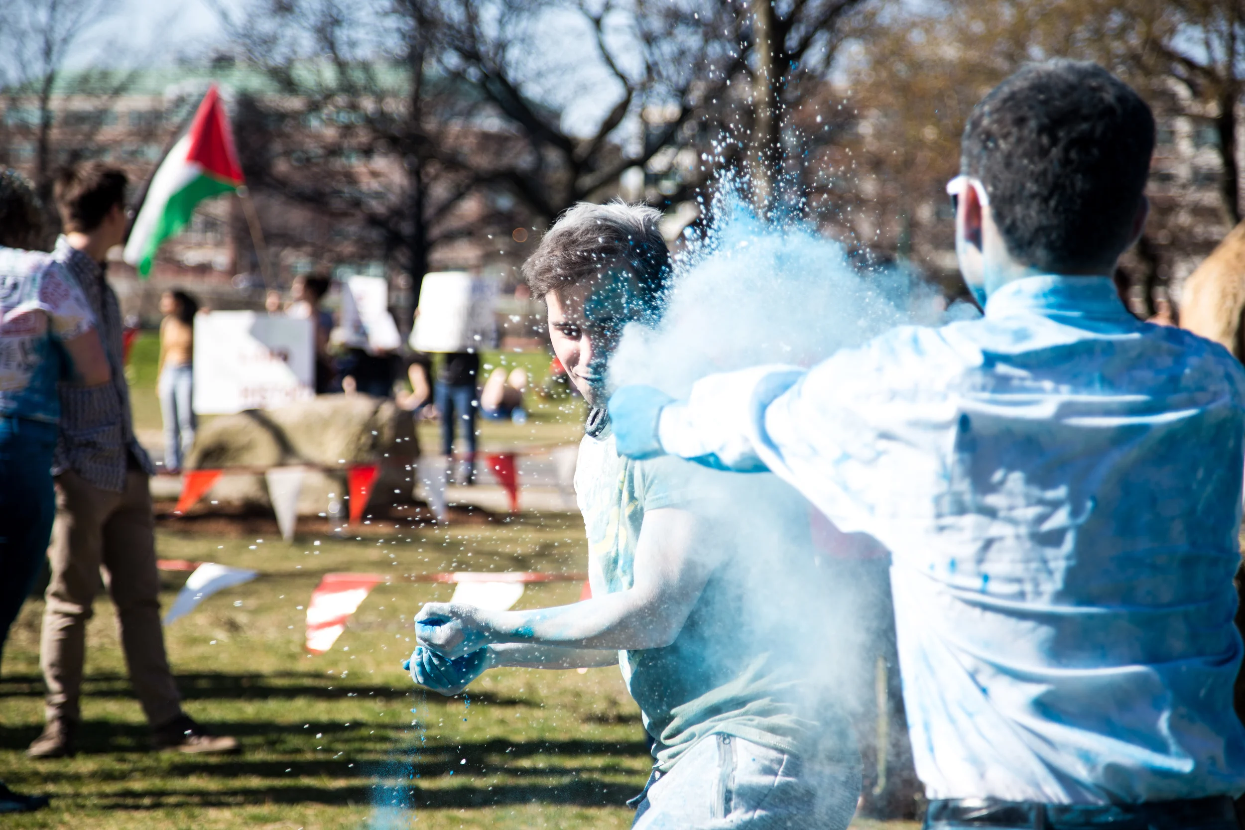 Jake Reiser (right) throws a handful of colored powder at Raphael Fils. 