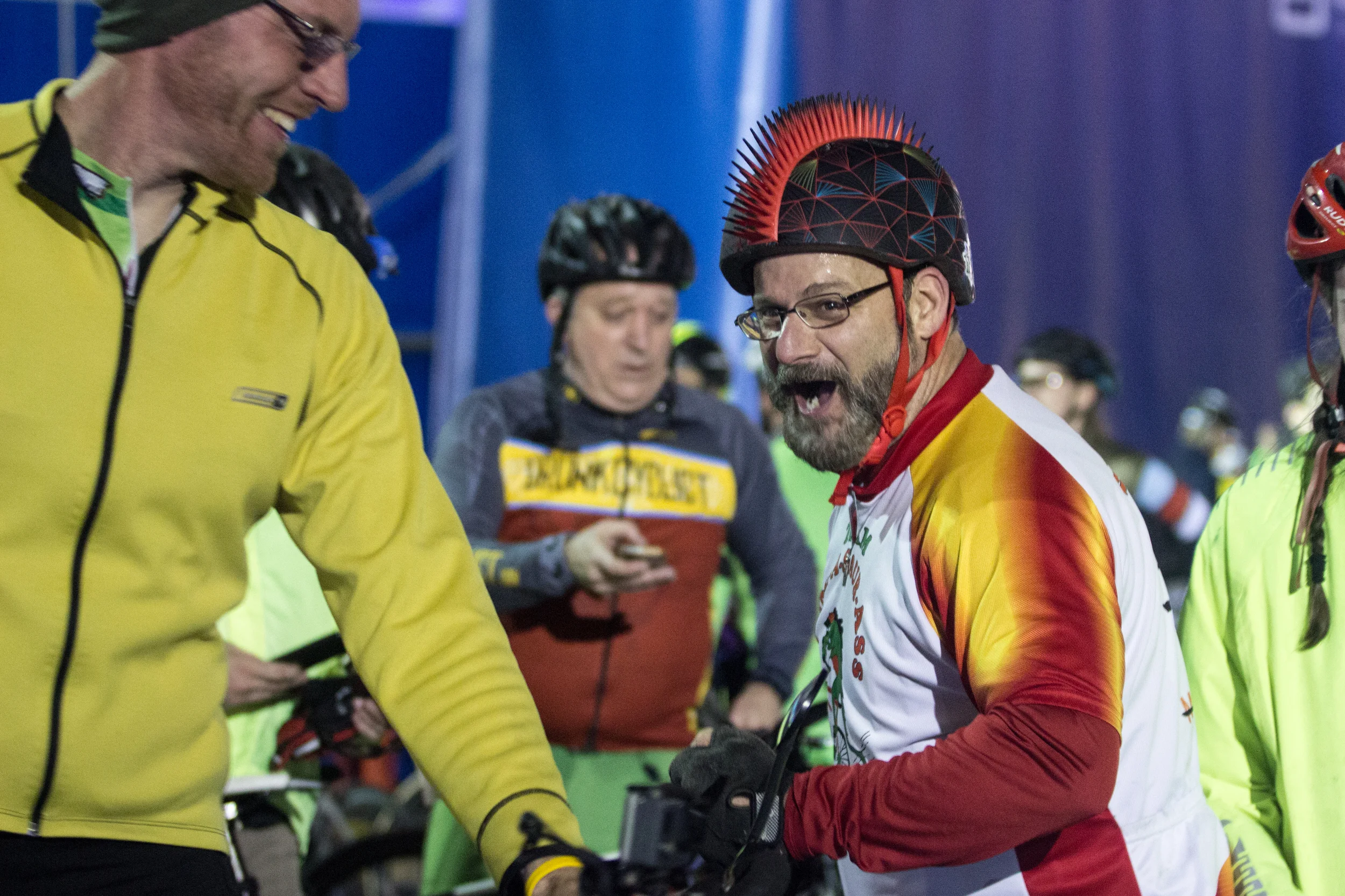 Dan Brossi (right) talks with fellow participants after completing the Midnight Marathon Bike Ride, which begins at midnight on April 18 in Hopkington, Mass., and traverses the route of the Boston Marathon. 