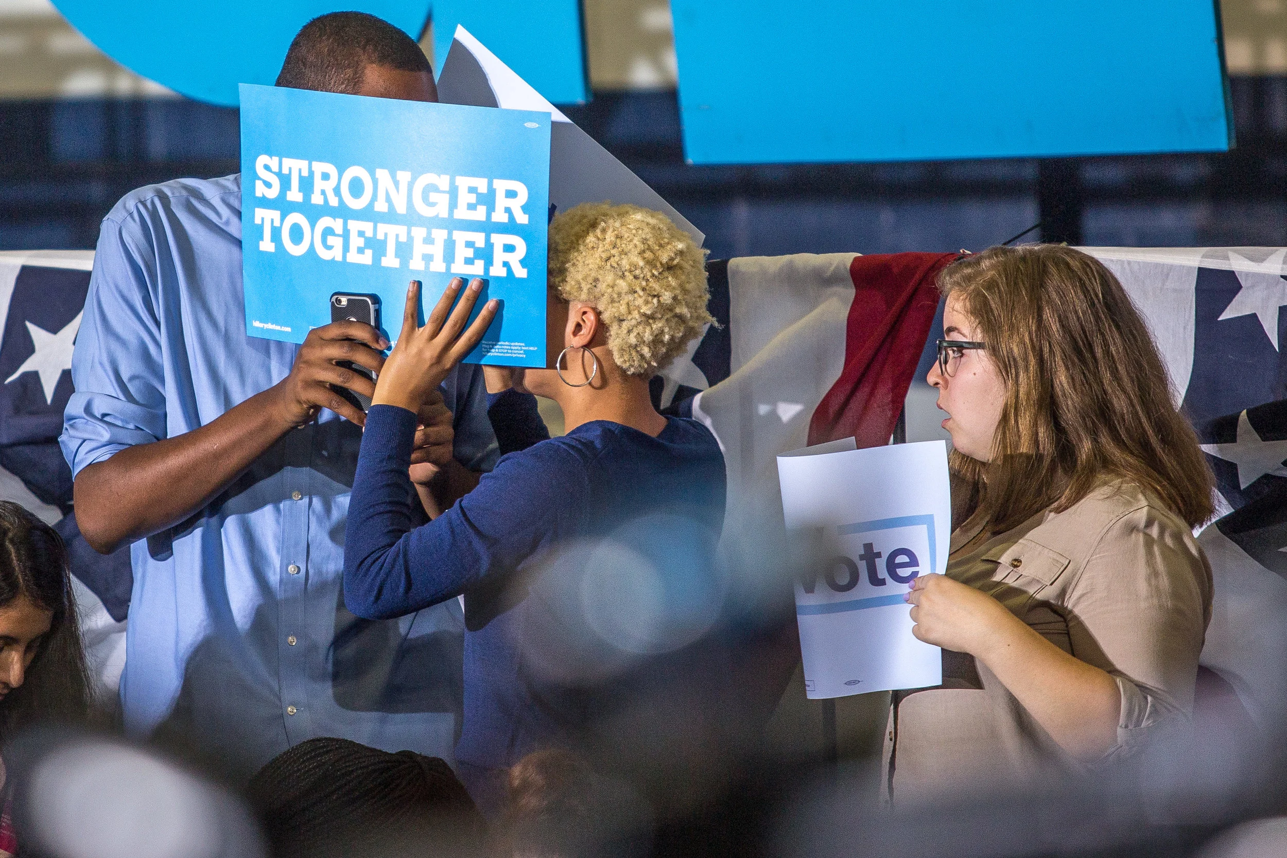 Hillary Clinton supporters speak behind their signs at Clinton's New College Compact Event at the University of New Hampshire, Durham, New Hampshire, September 28.