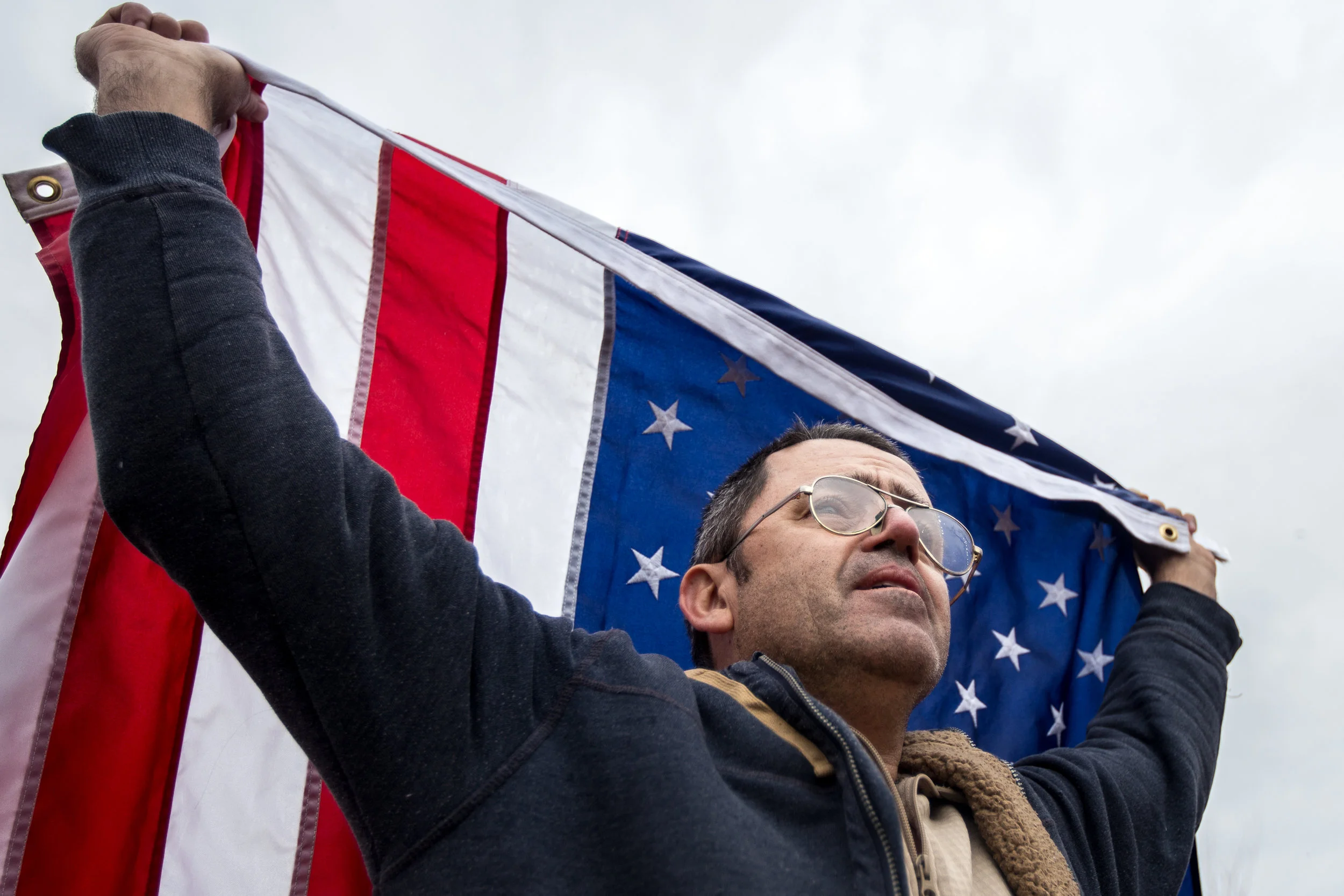 A Donald Trump supporter holds an American flag on the National Mall, Washington, D.C., during the inaugural ceremony, Jan. 20, 2017.