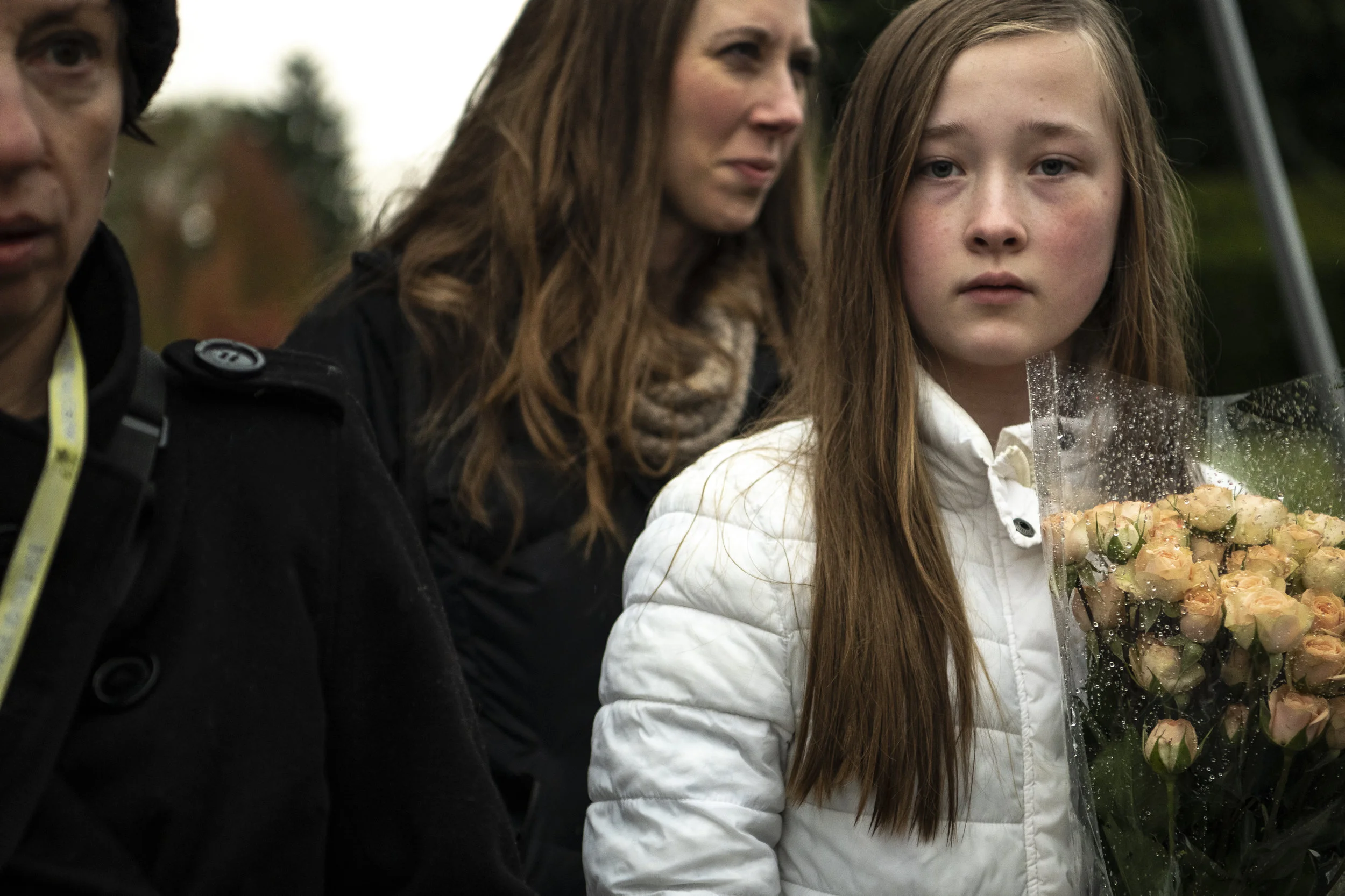 Megan Sabo, 12, right, with her mother Kristen, center, of Peters, wait for a police escort to be able to cross the street to add flowers to a memorial in front of the Tree of Life synagogue, Sunday, Oct. 28, 2018, in Squirrel Hill.