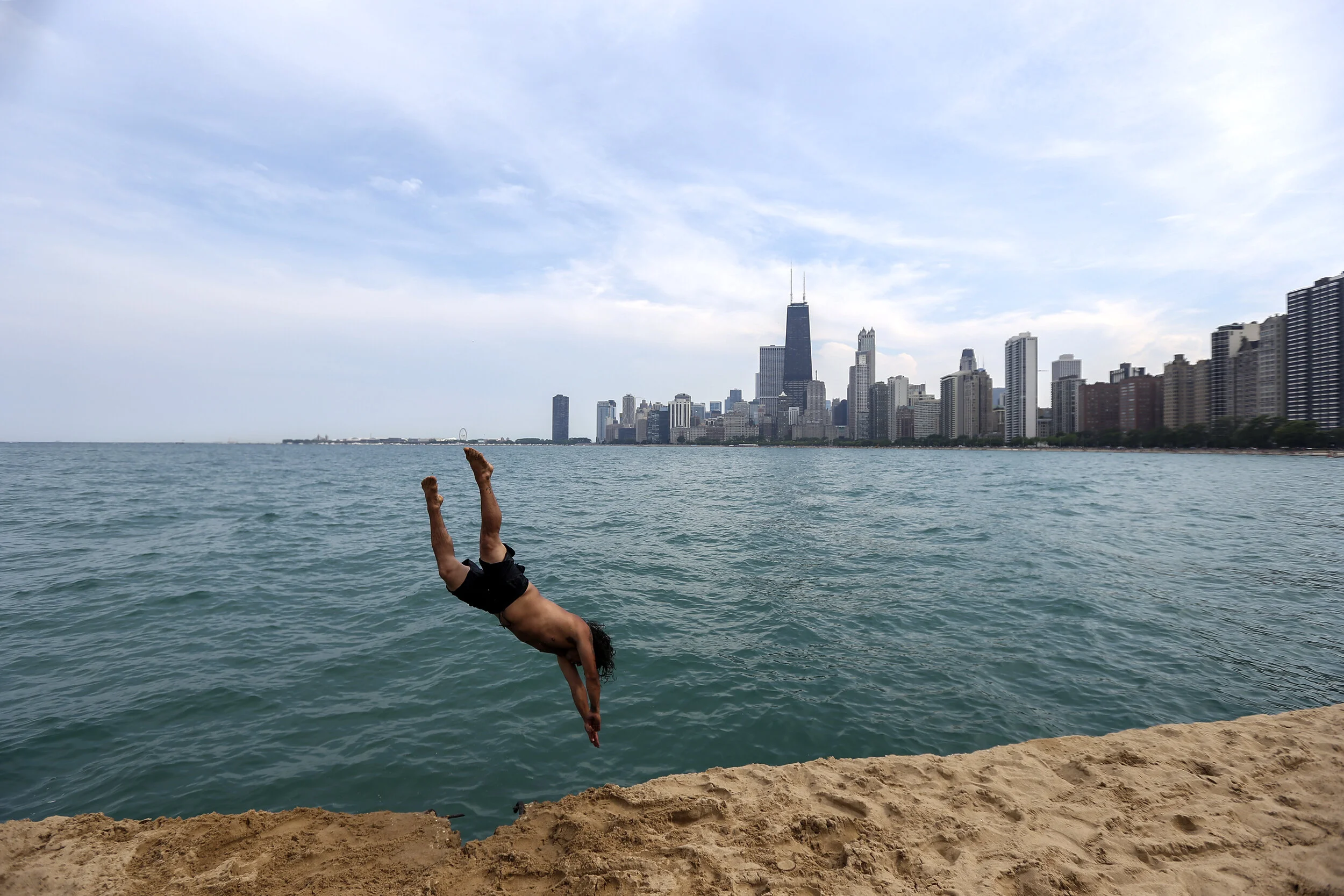  Allan Valencia, of Chicago, jumps into Lake Michigan near North Avenue Beach in Chicago on July 4, 2017.  