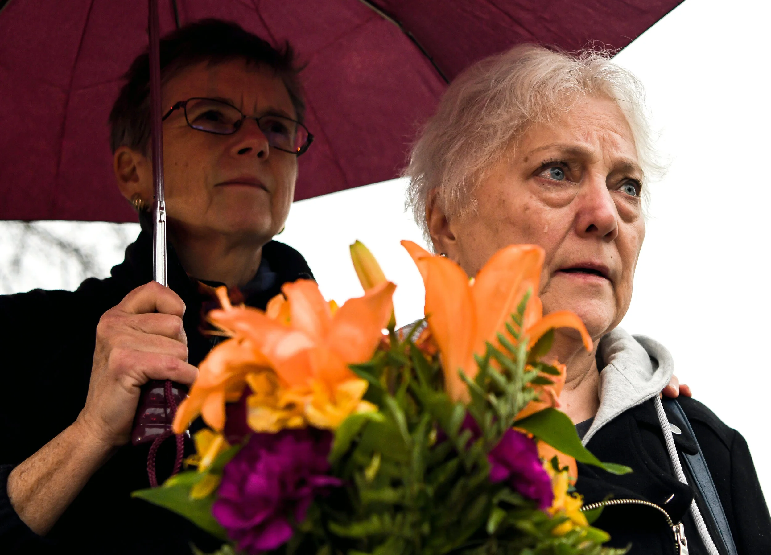  Veronica Pratt holds an umbrella over Linda Shab, both of Regent Square, as Ms. Shab cries as she waits to cross the street to add flowers to a makeshift memorial in front of the Tree of Life synagogue, Sunday, Oct. 28, 2018, in Squirrel Hill. 