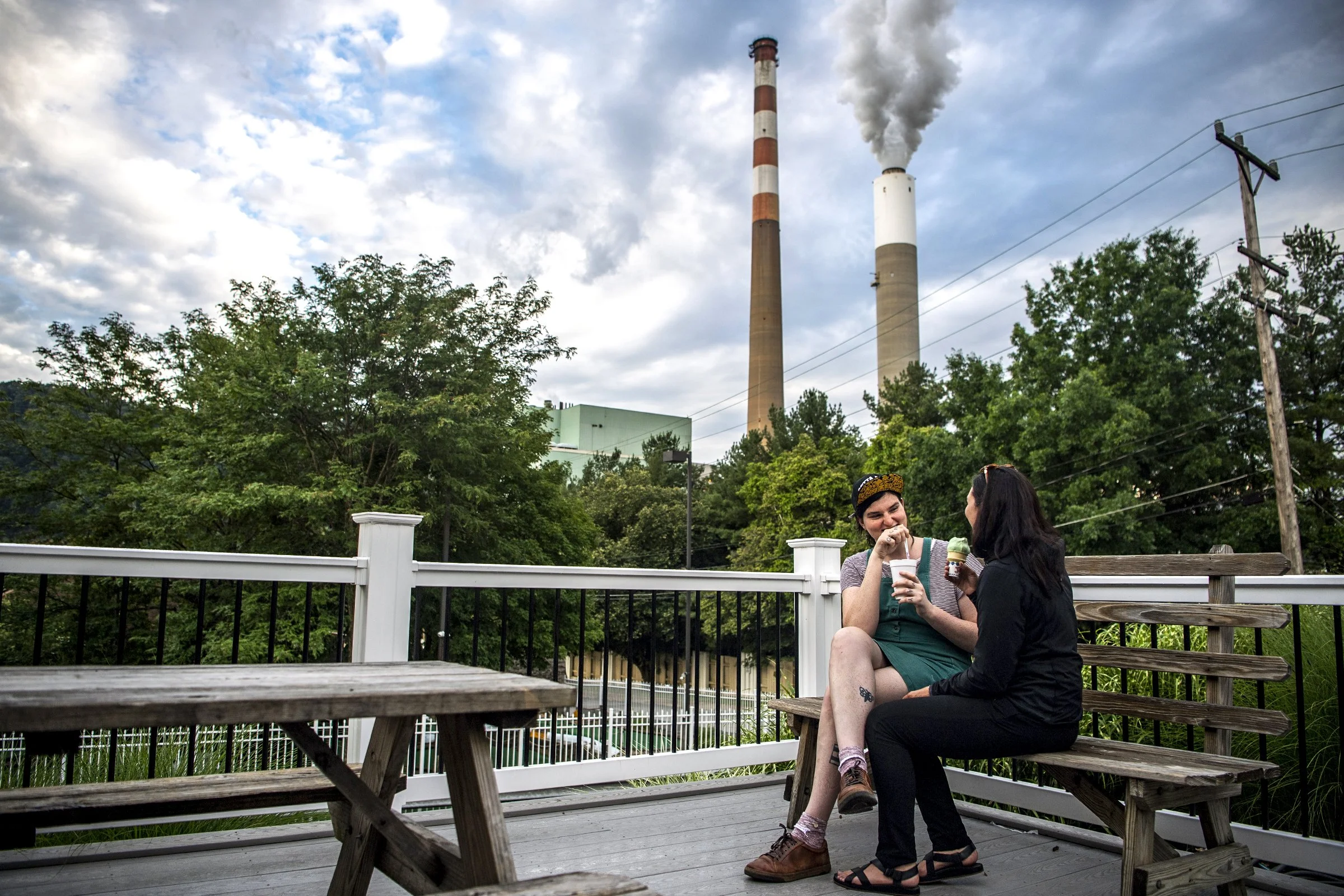  Lillyn Walsh and Katie Rickman, both Pittsburgh residents, sit outside at Glen’s Frozen Custard in Springdale, Pa., where the Cheswick Generating Station can be seen in the background, Tuesday, July 13, 2021. The power plant was initially scheduled 