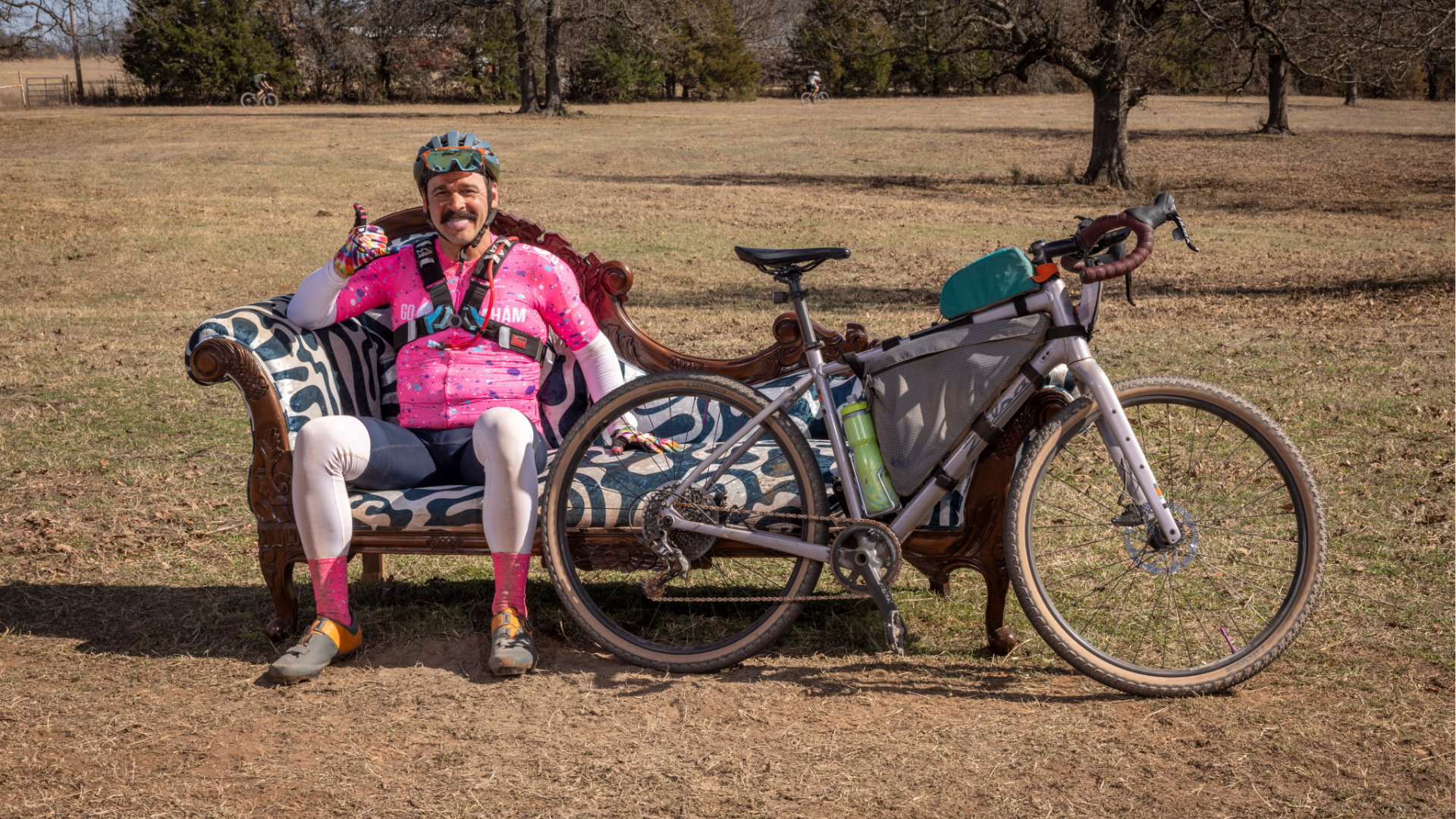aj finney in biking gear with bike on couch