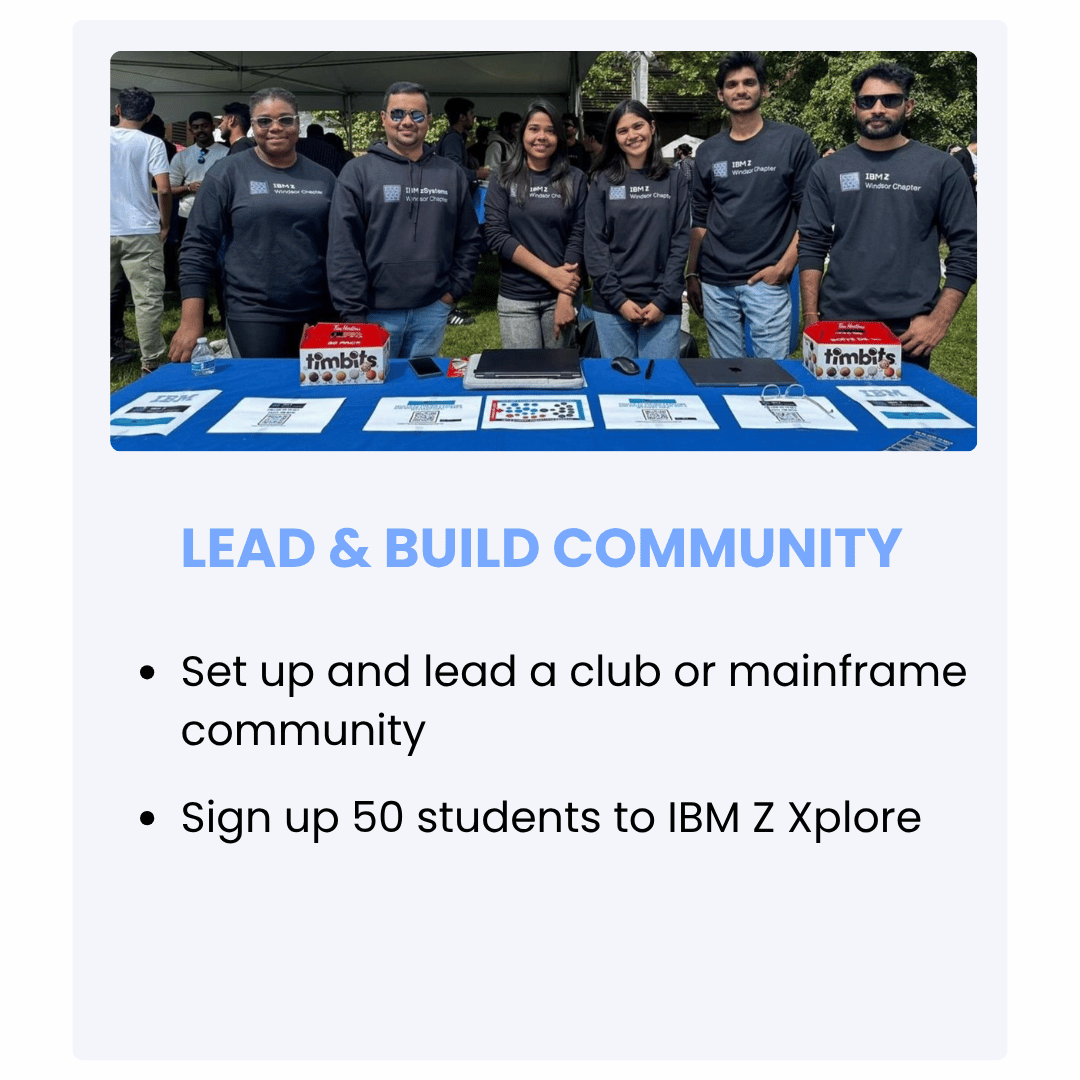 Group of six people standing behind a table at an outdoor community event, all wearing matching IBM Z Windsor Chapter hoodies, with signing materials and games on the table, promoting leading and building community.